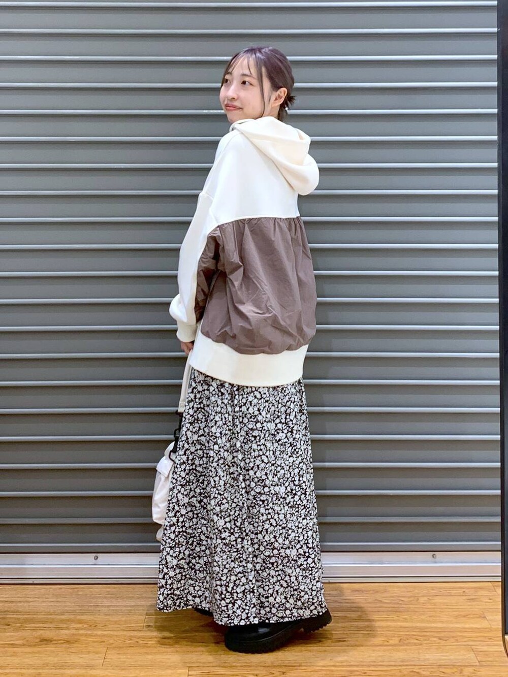 ホワイト系のショルダーバッグ、ブラック系のブーツ、ホワイト系のパーカーを着用したレディースの冬コーディネートの3枚目の写真