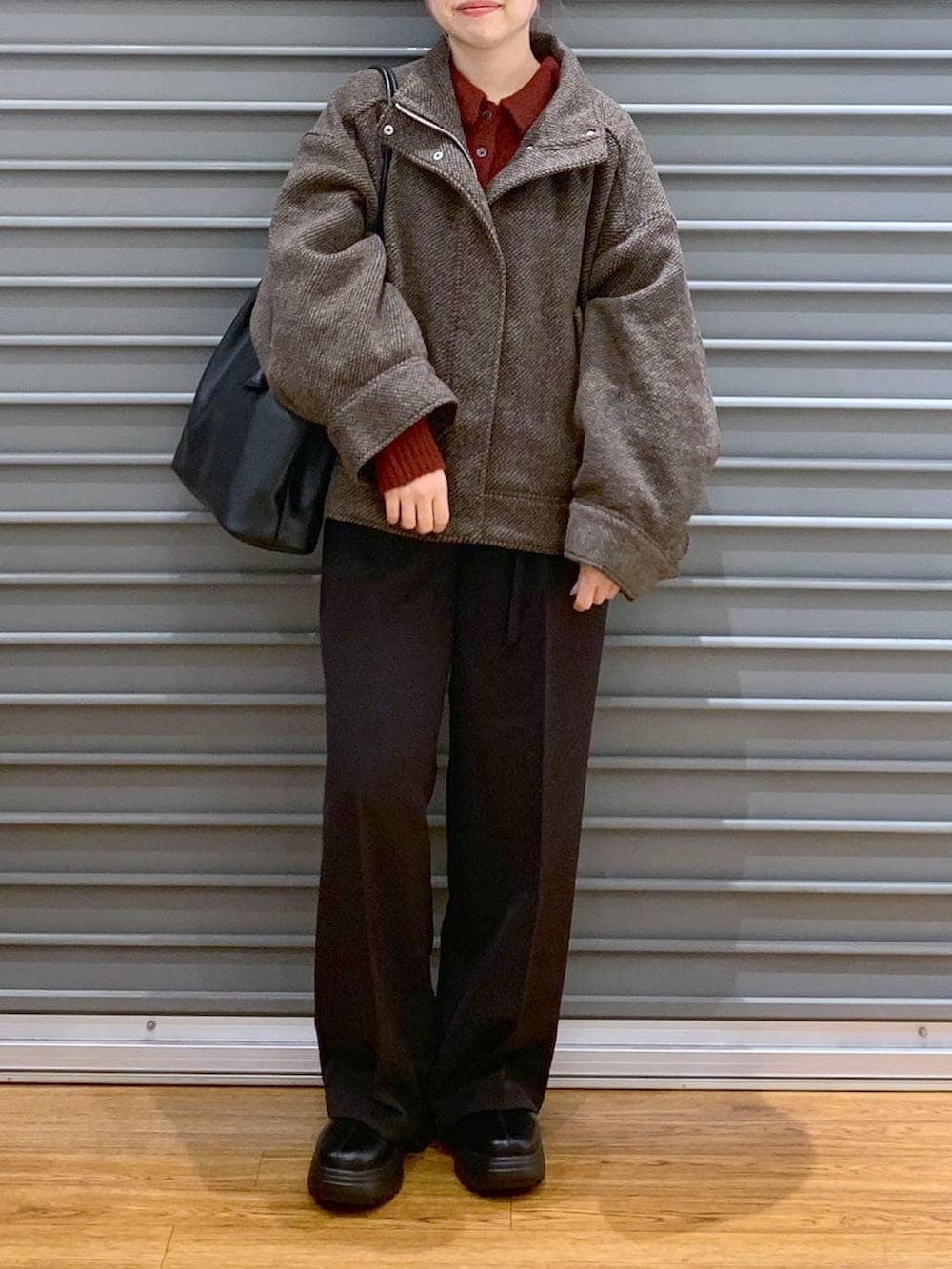 ブラウン系のブルゾン、ブラック系のブーツ、ブラック系のその他パンツを着用したレディースの冬コーディネートの5枚目の写真