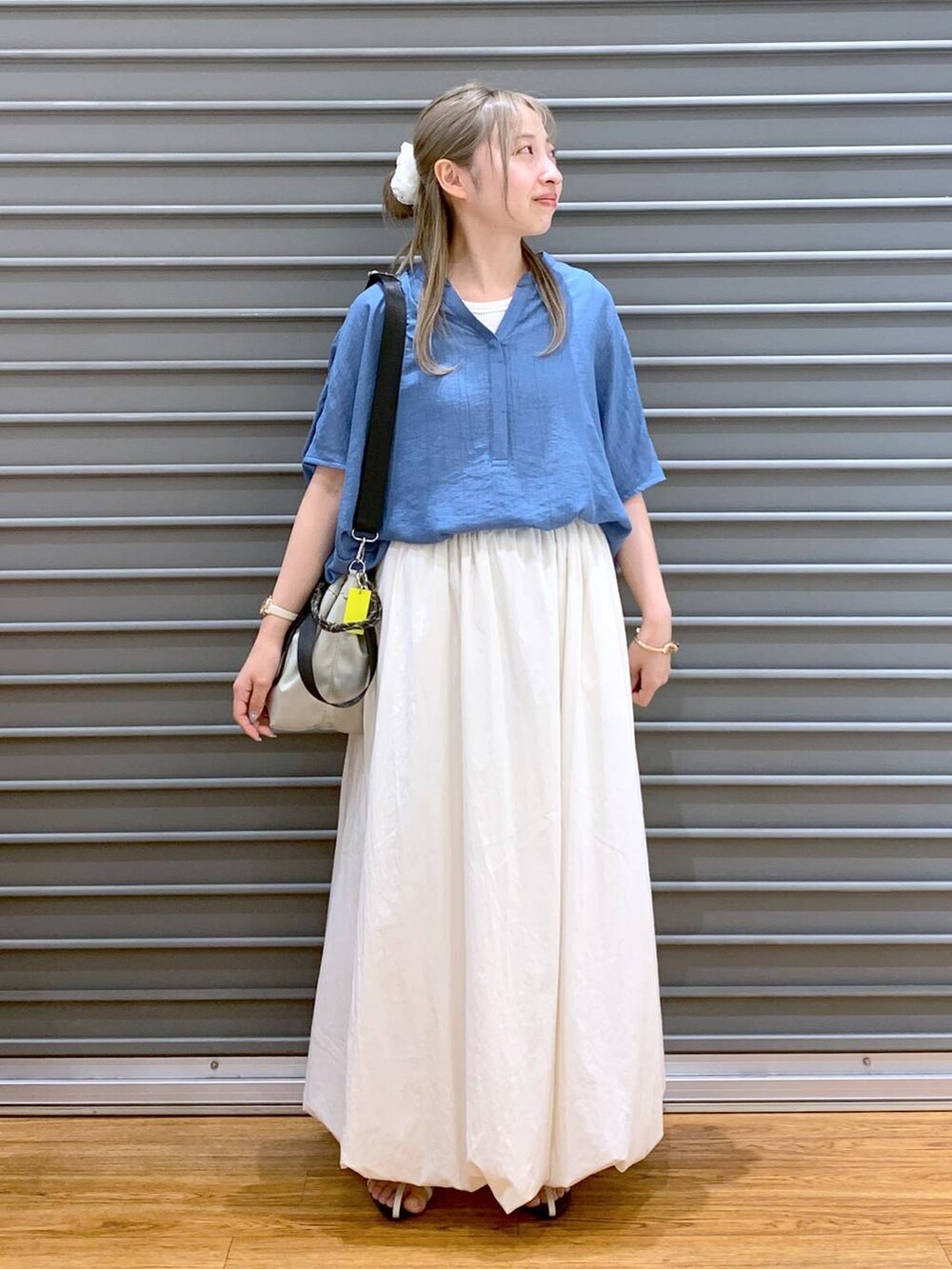 ホワイト系のサンダル、ホワイト系のスカート、グレー系のショルダーバッグを着用したレディースの夏コーディネートの4枚目の写真