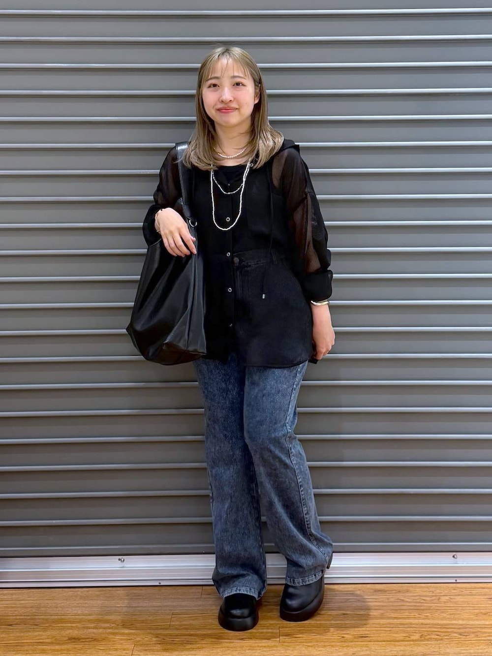 ブラック系のサンダル、ブルー系のデニムパンツ、グレー系のタンクトップを着用したレディースの春コーディネートの5枚目の写真