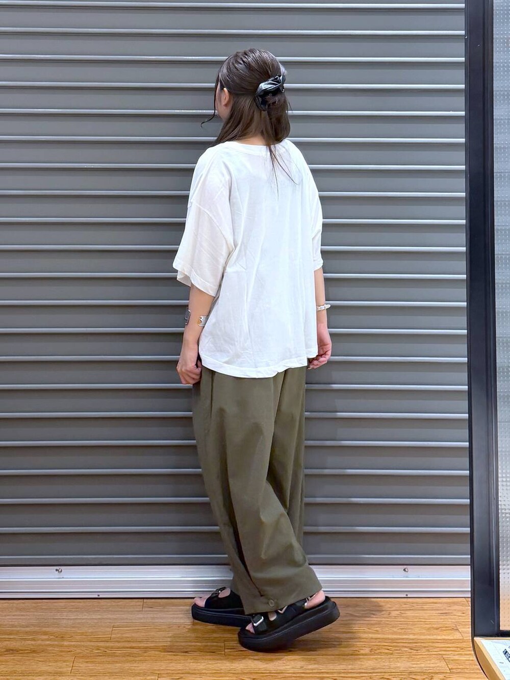 ブルー系のトートバッグ、ホワイト系のTシャツ/カットソー、ブラック系のサンダルを着用したレディースの夏コーディネートの3枚目の写真