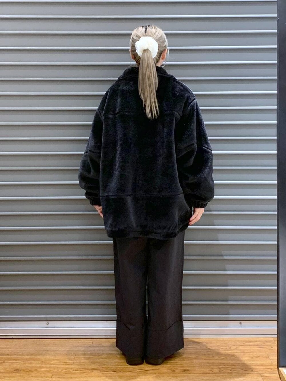 レッド系のニット/セーター、ブラック系のショルダーバッグ、ブラック系のブーツを着用したレディースの冬コーディネートの2枚目の写真