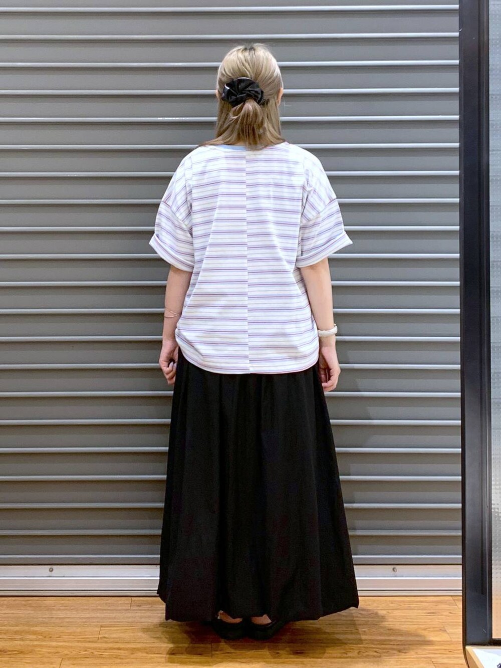 ホワイト系のサンダル、グレー系のトートバッグ、ブラック系のスカートを着用したレディースの夏コーディネートの2枚目の写真