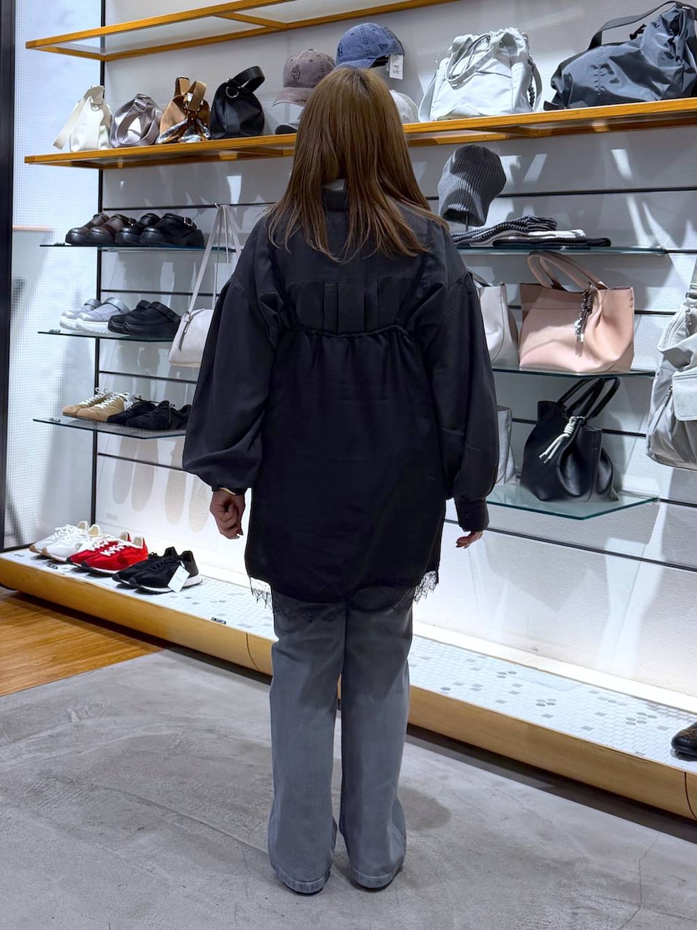 シルバー系のパンプス、グレー系のシャツ/ブラウス、ブラック系のトートバッグを着用したレディースの春コーディネートの2枚目の写真