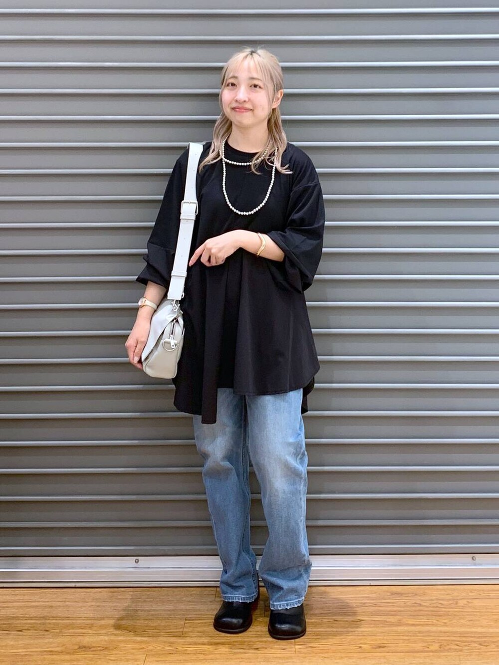 ブルー系のデニムパンツ、グレー系のショルダーバッグ、ブラック系のその他シューズを着用したレディースの秋コーディネートの6枚目の写真