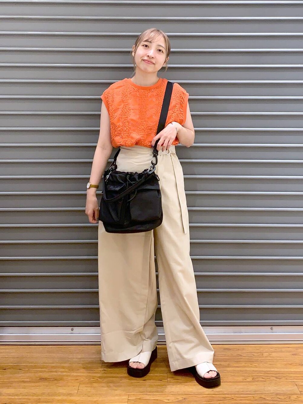 ブラック系のショルダーバッグ、オレンジ系のTシャツ/カットソー、ホワイト系のその他パンツを着用したレディースの夏コーディネートの5枚目の写真
