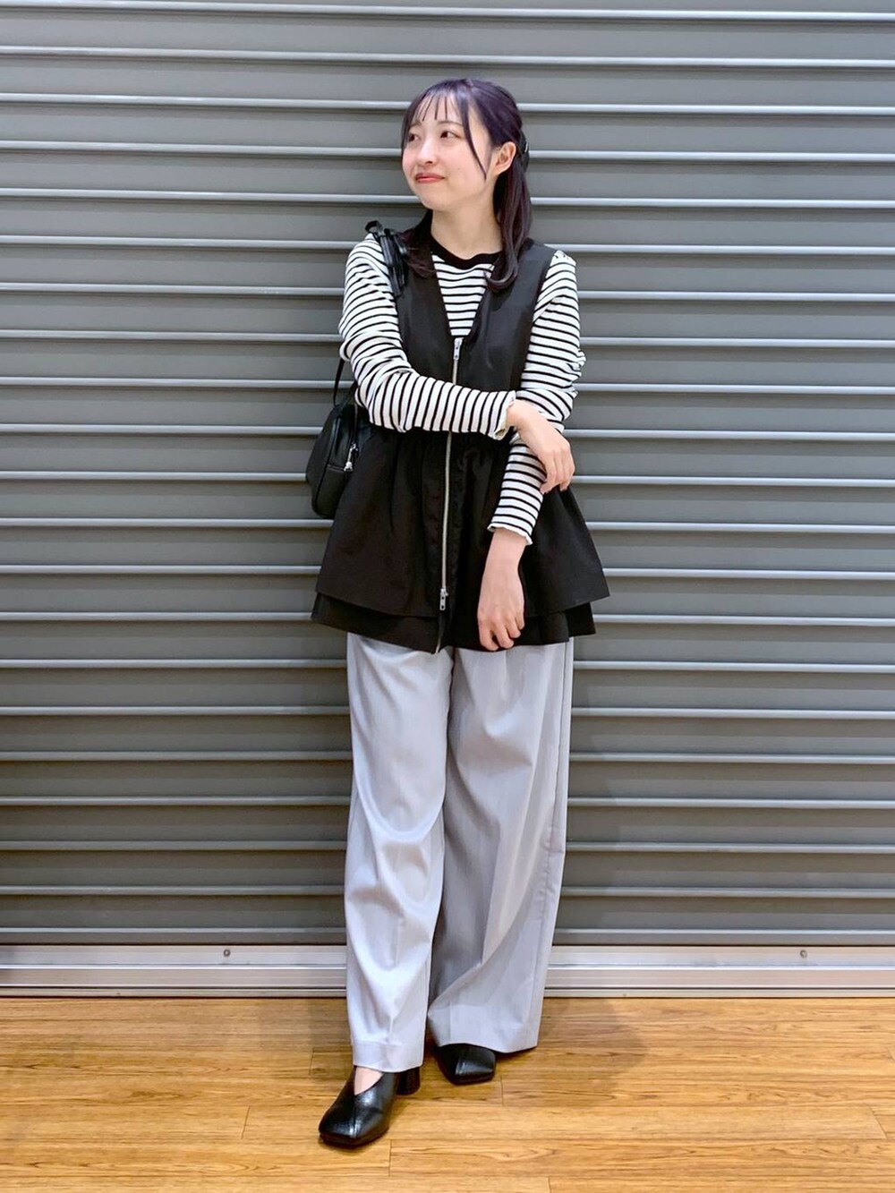 ブラック系のショルダーバッグ、ブラック系のパンプス、ブラック系のベストを着用したレディースの春コーディネートの5枚目の写真