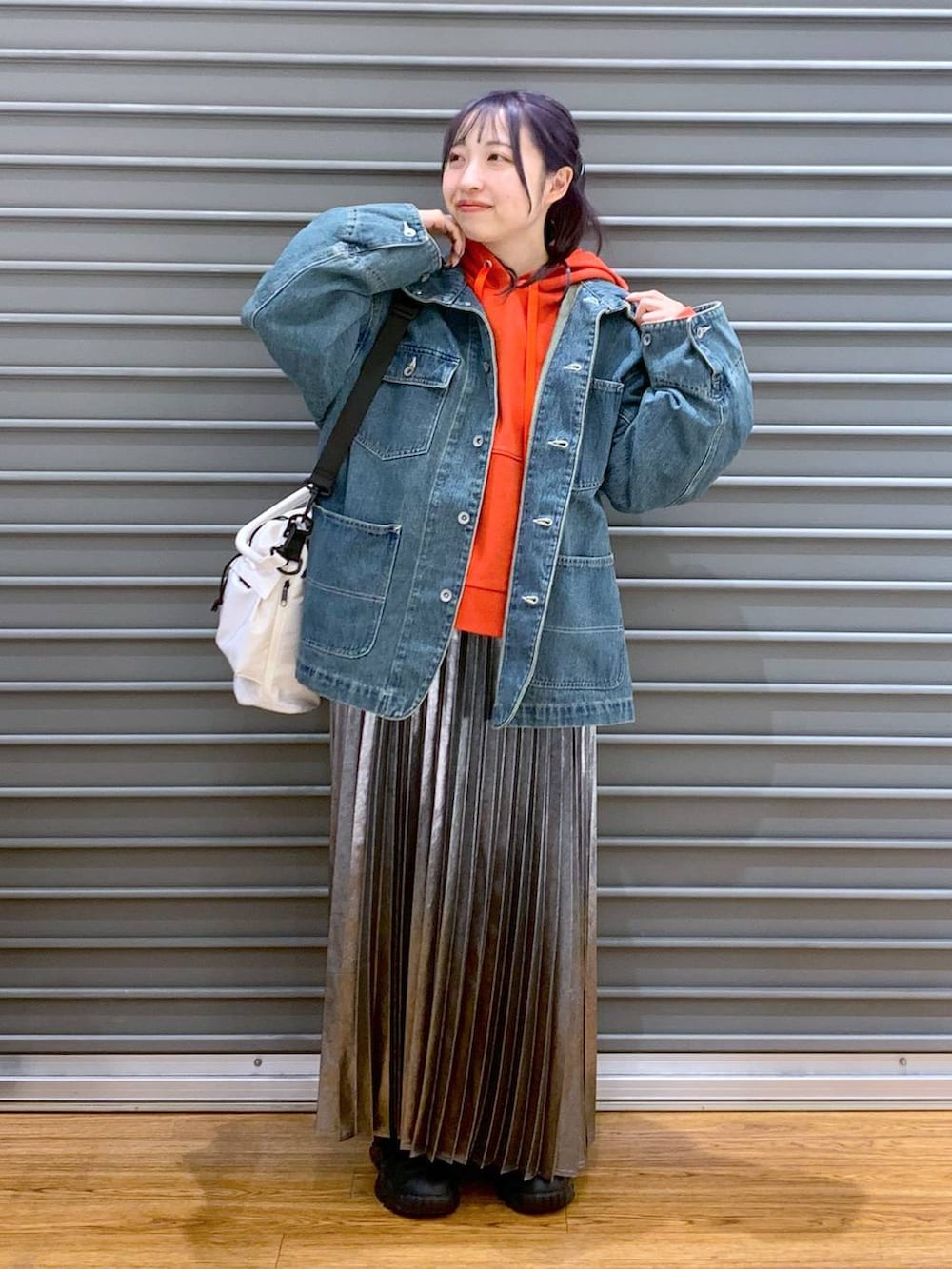 ホワイト系のショルダーバッグ、ブルー系のデニムジャケット、グレー系のスカートを着用したレディースの春コーディネートの5枚目の写真