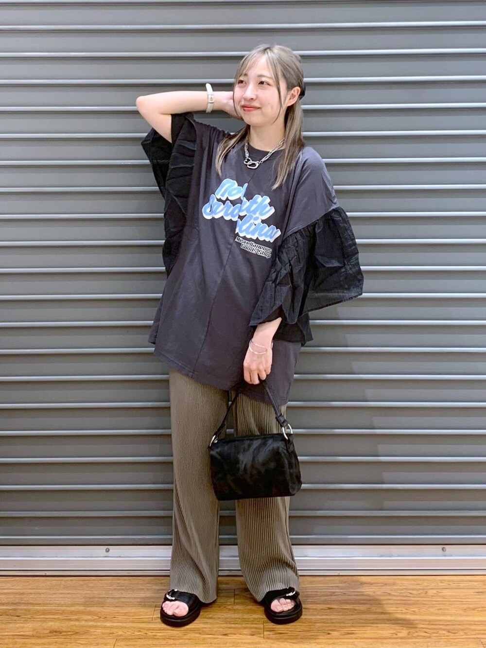 ブラック系のサンダル、ブラウン系のその他パンツ、ブラック系のハンドバッグを着用したレディースの春コーディネートの4枚目の写真