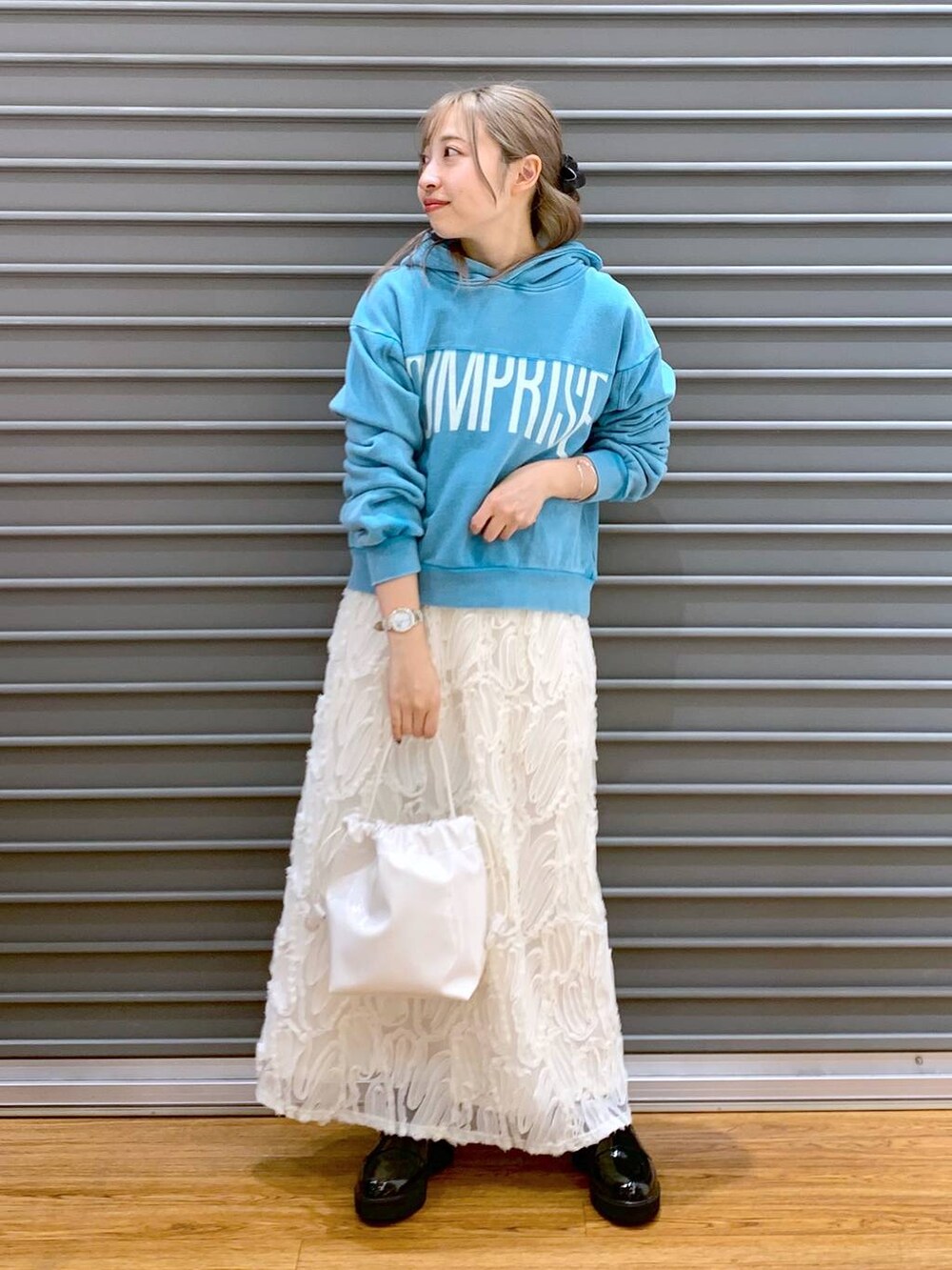 ブルー系のパーカー、ホワイト系のスカート、ブラック系のローファーを着用したレディースの冬コーディネートの6枚目の写真