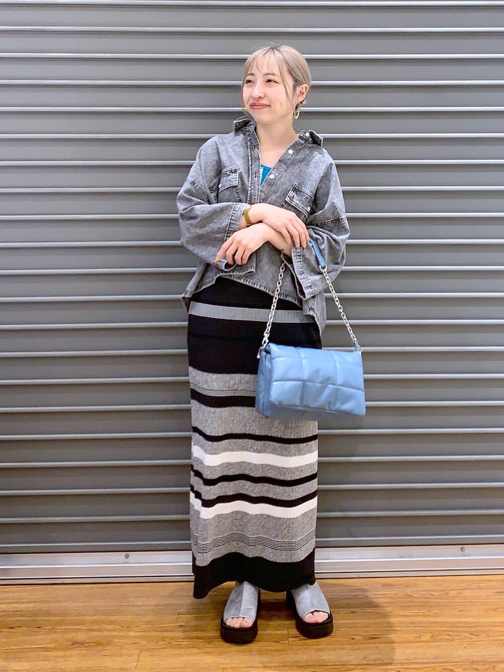 ブルー系のショルダーバッグ、ブラック系のシャツ/ブラウス、グレー系のサンダルを着用したレディースの春コーディネートの5枚目の写真