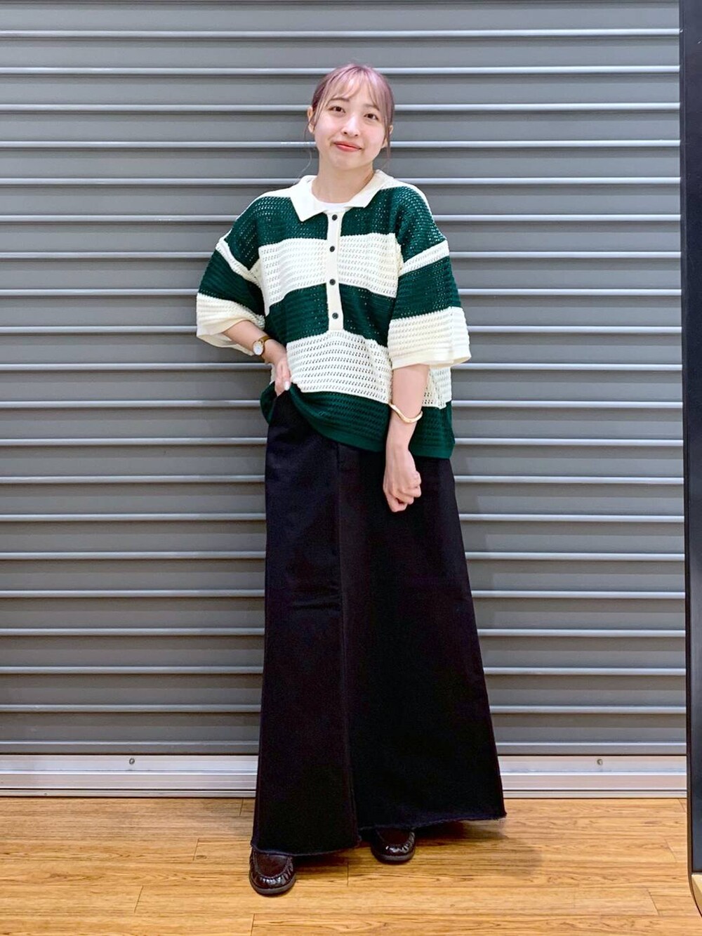 グリーン系のニット/セーター、グレー系のスカート、ブラウン系のボストンバッグを着用したレディースの秋コーディネートの6枚目の写真