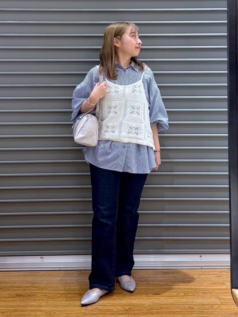 グレー系のボストンバッグ、シルバー系のパンプス、ブルー系のシャツ/ブラウスを着用したレディースの春コーディネートの4枚目の写真
