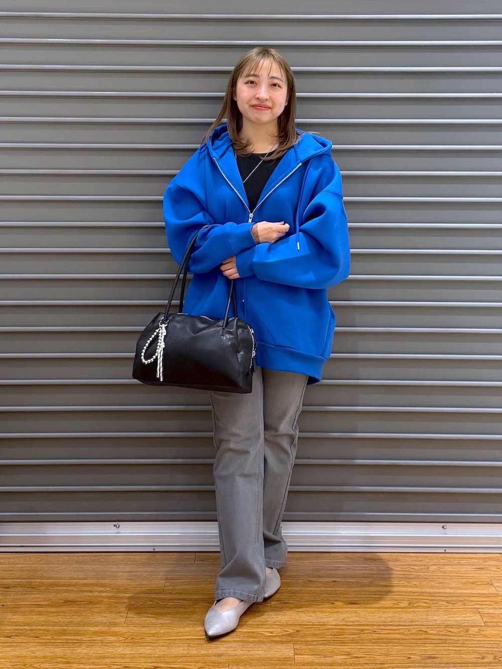ブルー系のパーカー、ブラック系のTシャツ/カットソー、シルバー系のパンプスを着用したレディースの春コーディネートの7枚目の写真