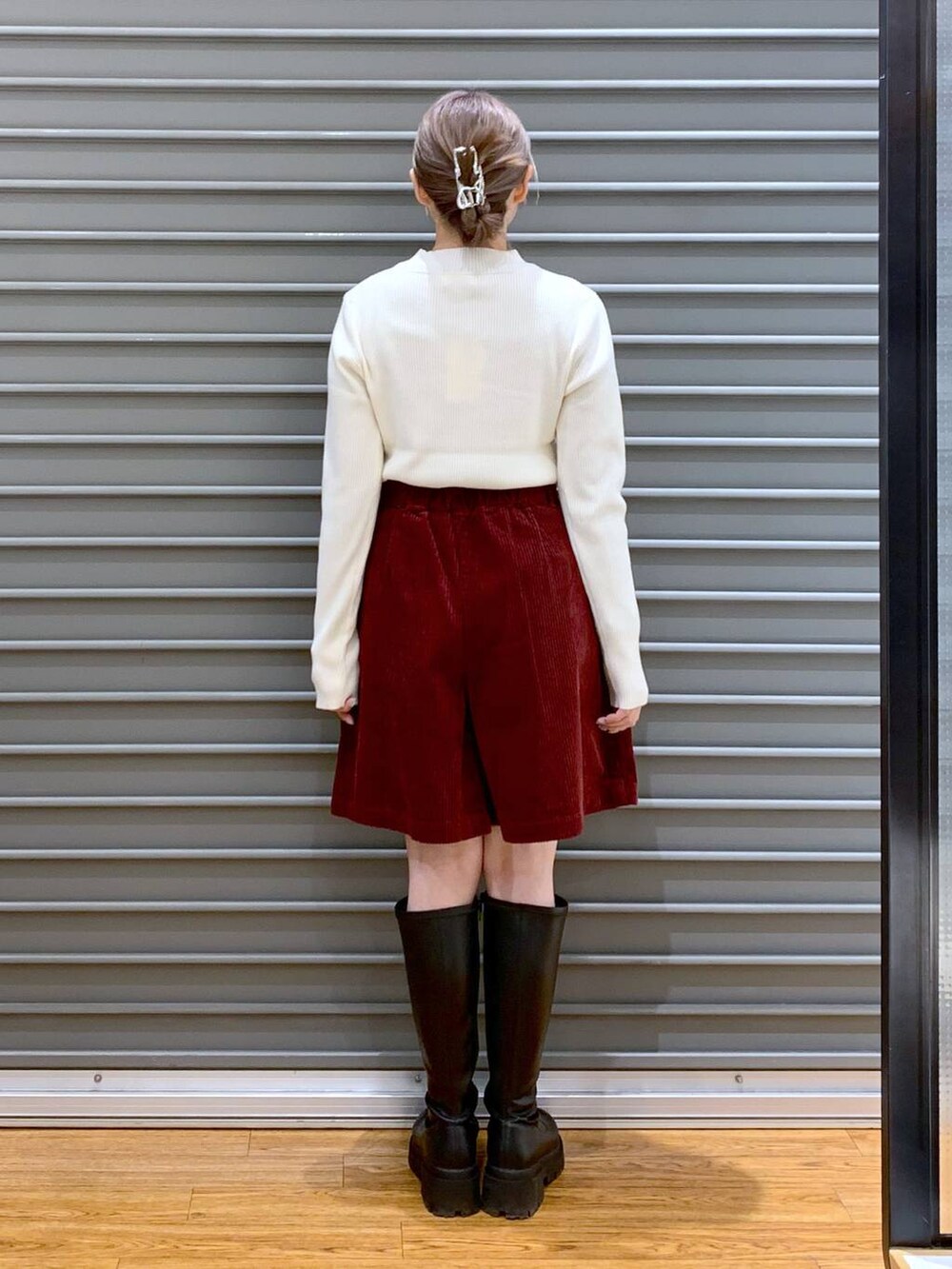 ホワイト系のポンチョ、ホワイト系のニット/セーター、ブラック系のブーツを着用したレディースの冬コーディネートの3枚目の写真