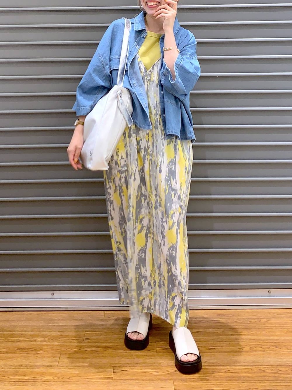 イエロー系のワンピース、ブルー系のシャツ/ブラウス、ホワイト系のサンダルを着用したレディースの夏コーディネートの5枚目の写真