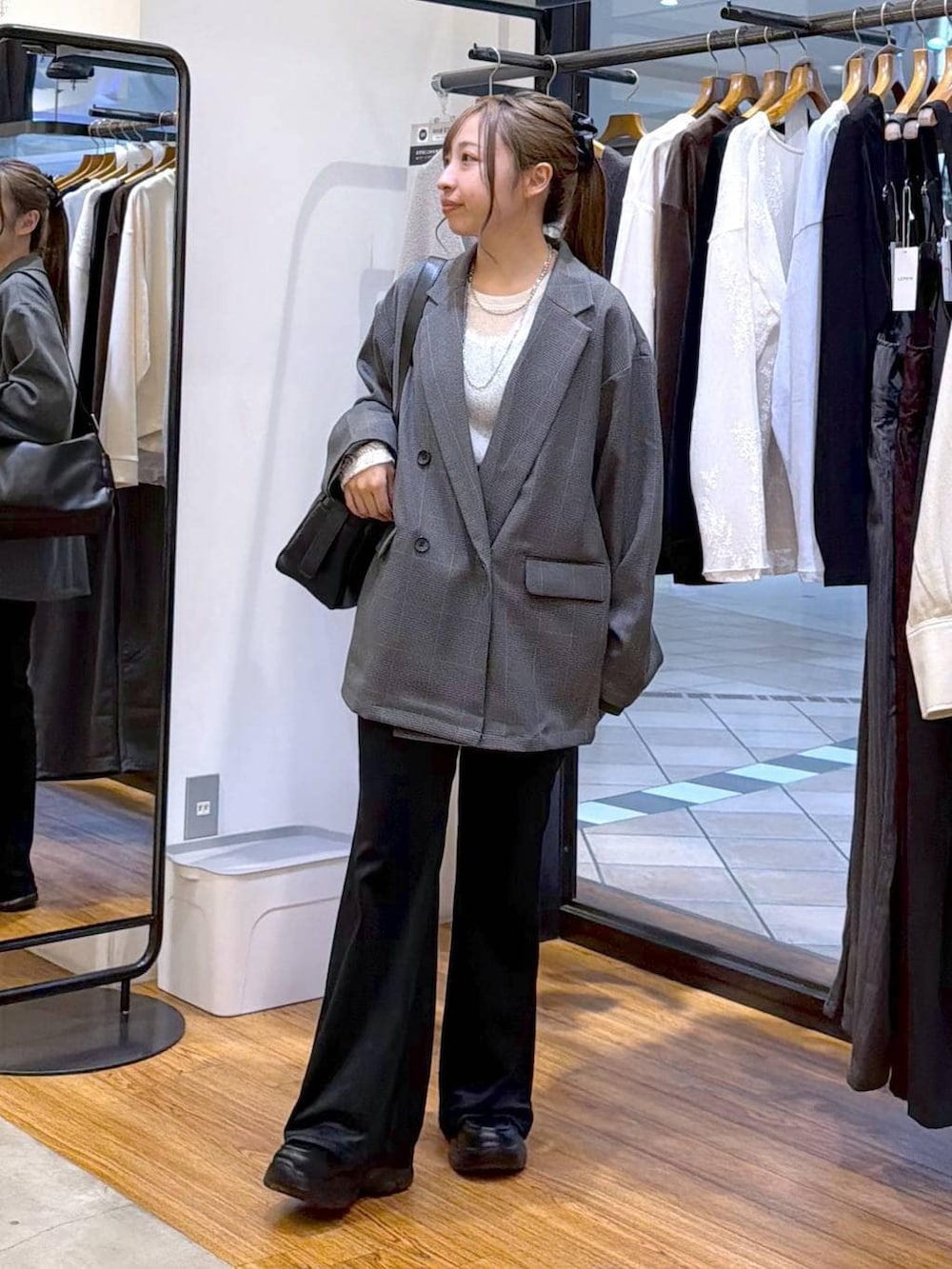 ブラック系のローファー、グレー系のテーラードジャケット、ホワイト系のTシャツ/カットソーを着用したレディースの秋コーディネートの4枚目の写真