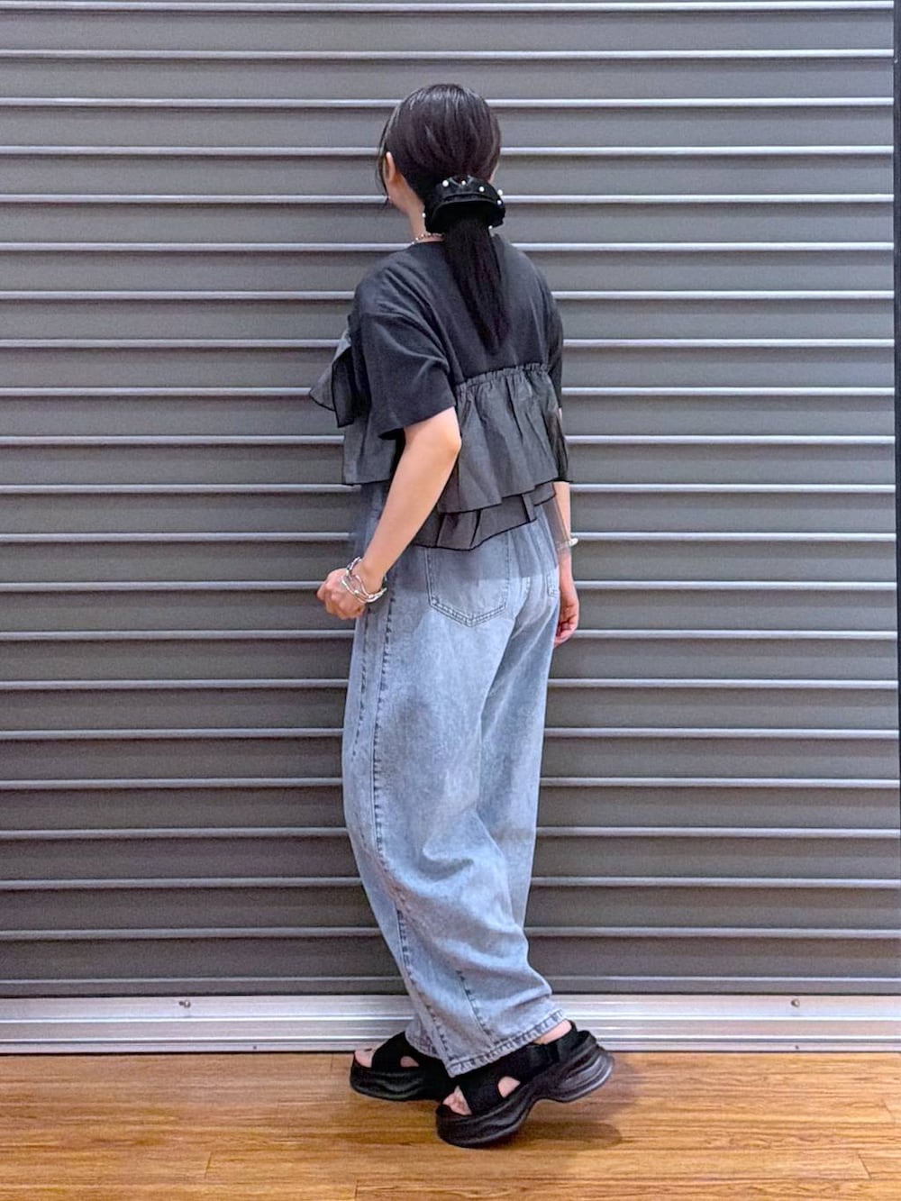ブラック系のショルダーバッグ、ブラック系のサンダル、グレー系のTシャツ/カットソーを着用したレディースの夏コーディネートの3枚目の写真
