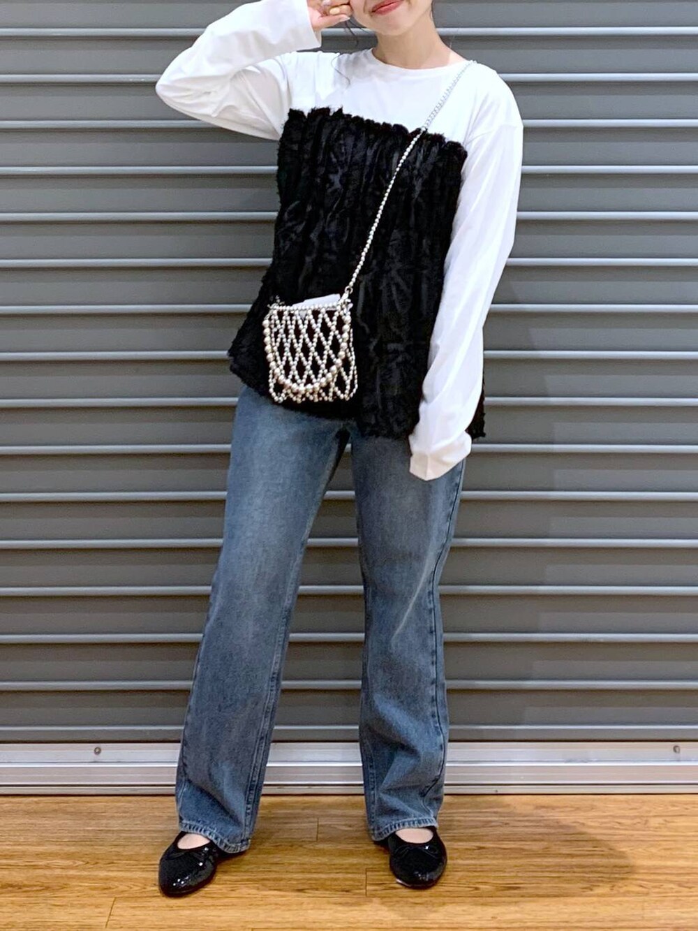 シルバー系のショルダーバッグ、ブルー系のデニムパンツ、ブラック系のバレエシューズを着用したレディースの秋コーディネートの5枚目の写真