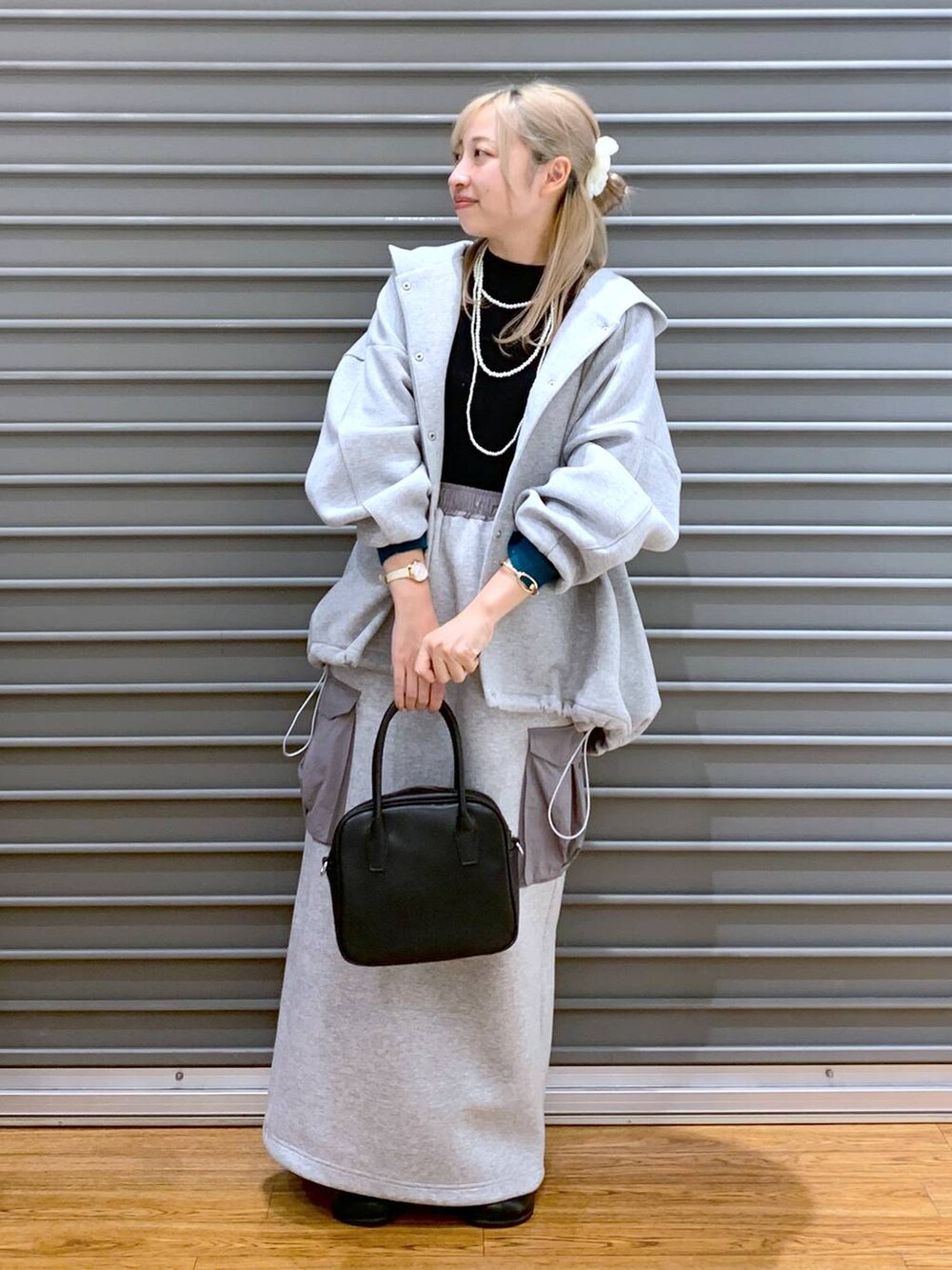 グレー系のブルゾン、ブラック系のニット/セーター、グレー系のスカートを着用したレディースの秋コーディネートの7枚目の写真