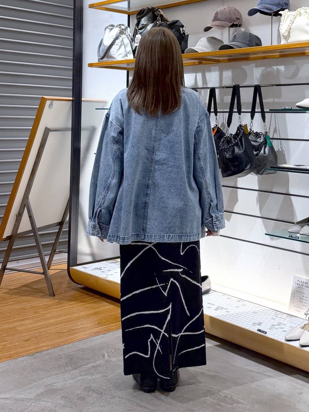 ホワイト系のTシャツ/カットソー、ブルー系のシャツ/ブラウス、ブラック系のショルダーバッグを着用したレディースの冬コーディネートの2枚目の写真