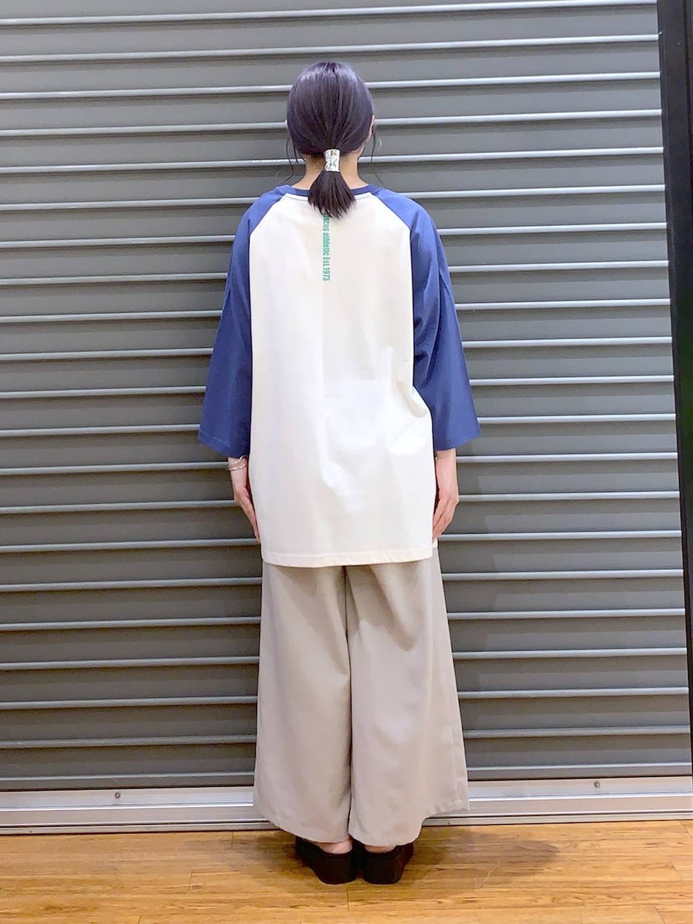 ブルー系のTシャツ/カットソー、ベージュ系のその他パンツ、ブラック系のショルダーバッグを着用したレディースの春コーディネートの2枚目の写真