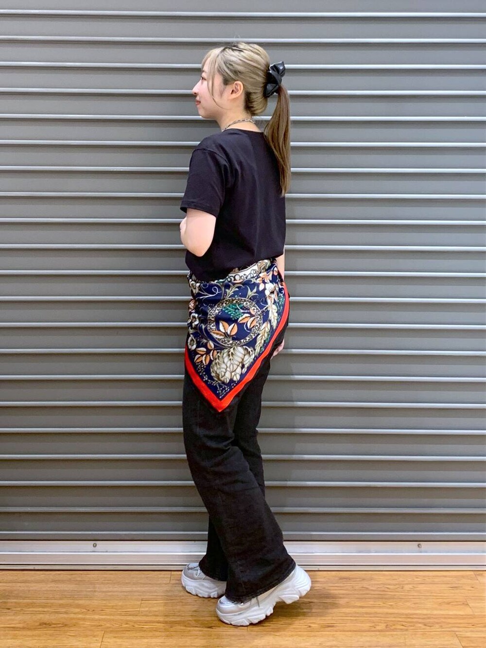 ブラック系のTシャツ/カットソー、ブラック系のデニムパンツ、シルバー系のスニーカーを着用したレディースの春コーディネートの3枚目の写真