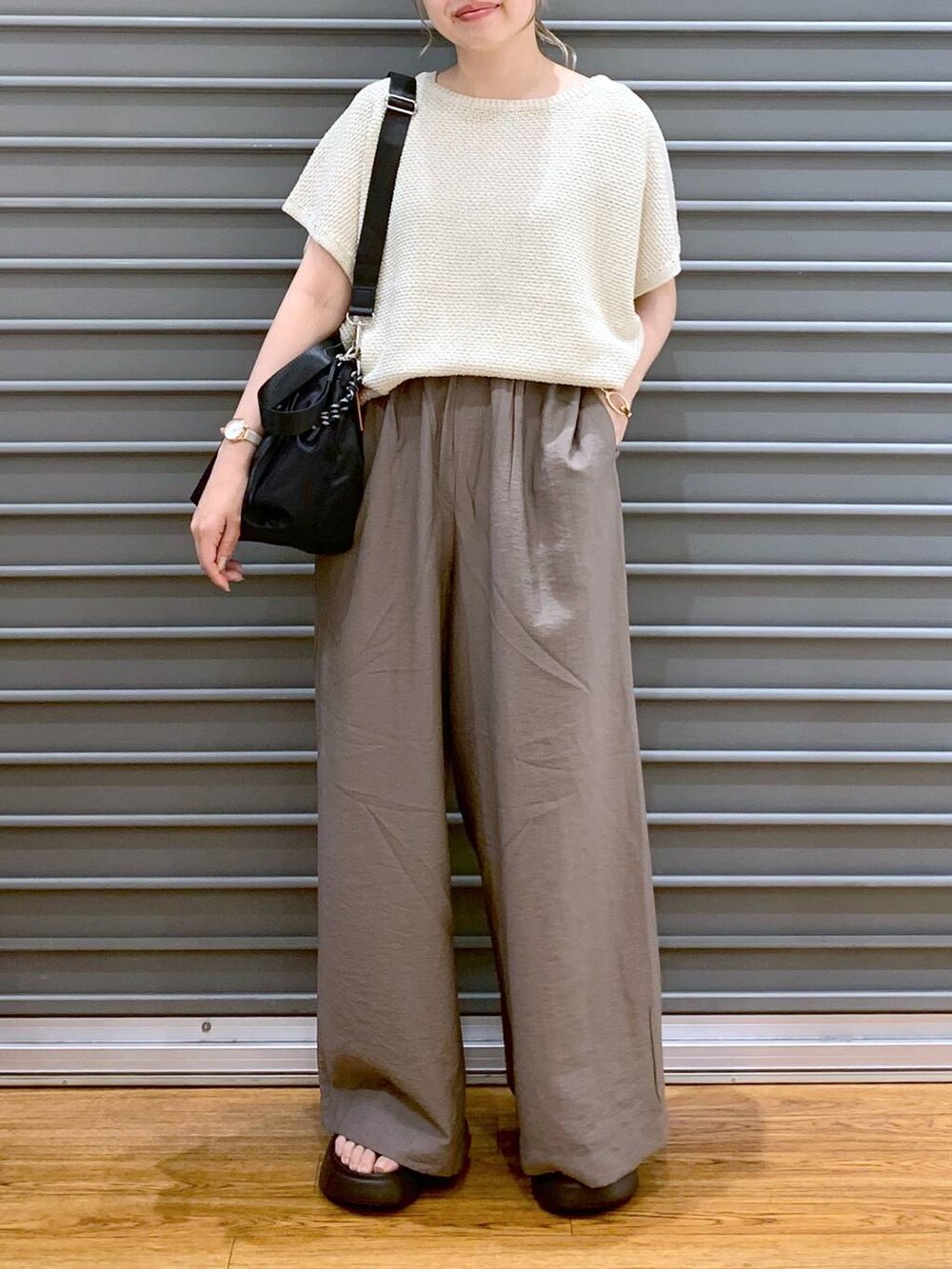 ホワイト系のニット/セーター、ブラウン系のサンダル、ブラック系のショルダーバッグを着用したレディースの夏コーディネートの5枚目の写真
