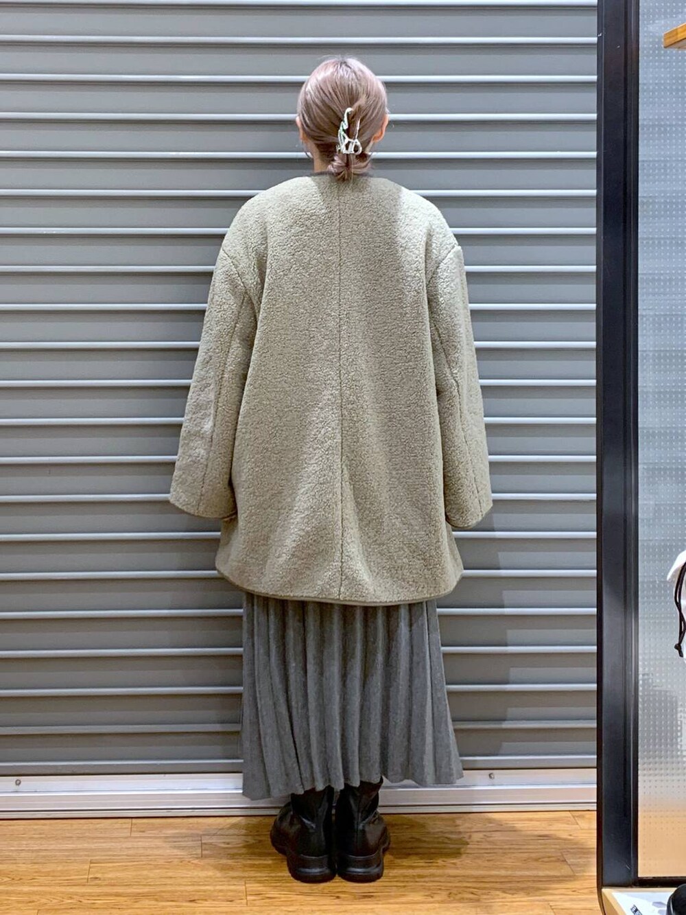 ブラック系のショルダーバッグ、グリーン系のその他アウター、ブラック系のブーツを着用したレディースの冬コーディネートの2枚目の写真