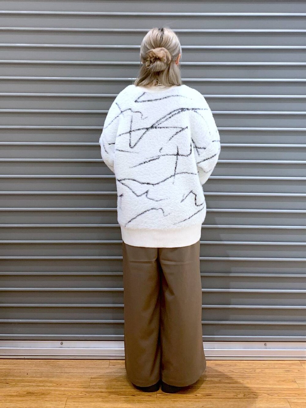 ブラウン系のその他パンツ、ホワイト系のカーディガン/ボレロ、ブラック系のブーツを着用したレディースの秋コーディネートの2枚目の写真