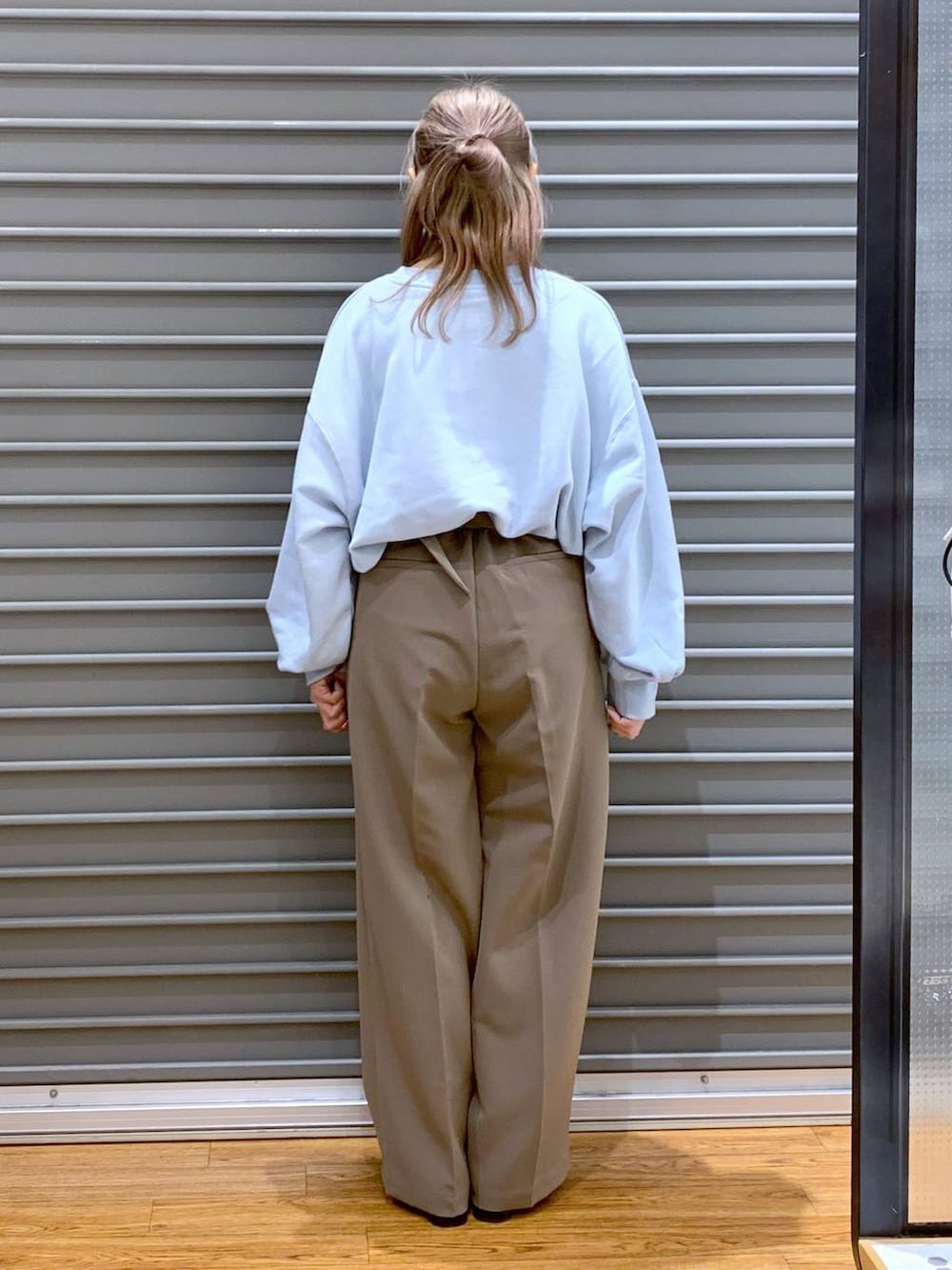 ブラック系のブーツ、ブラウン系のスーツパンツ、ブラック系のショルダーバッグを着用したレディースの冬コーディネートの2枚目の写真