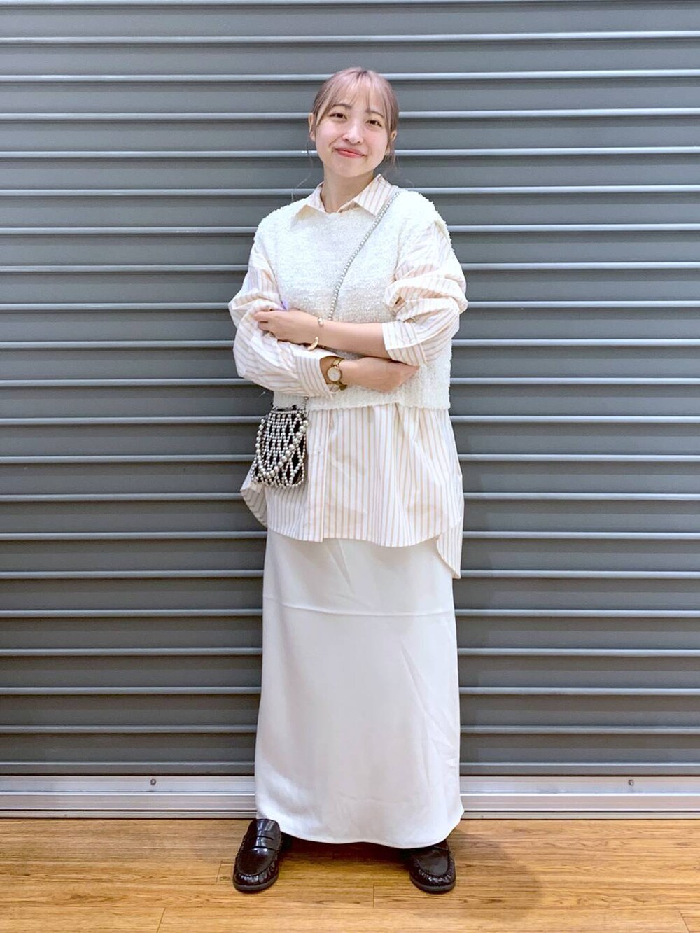 シルバー系のショルダーバッグ、ホワイト系のスカート、オレンジ系のシャツ/ブラウスを着用したレディースの秋コーディネートの4枚目の写真