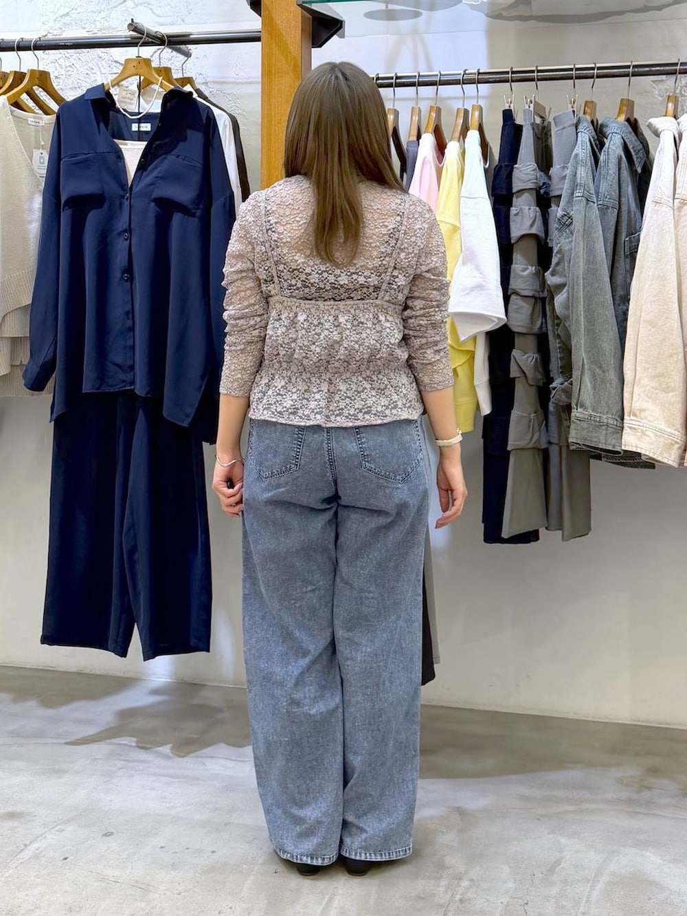 ブラック系のショルダーバッグ、ブルー系のデニムパンツ、グレー系のTシャツ/カットソーを着用したレディースの春コーディネートの2枚目の写真