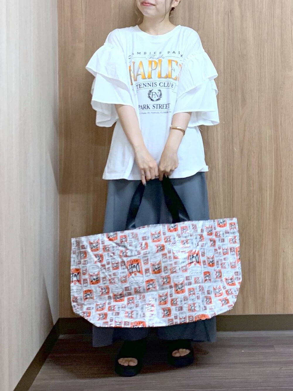 グレー系のスカート、グレー系のトートバッグ、ブラック系のサンダルを着用したレディースの夏コーディネートの3枚目の写真