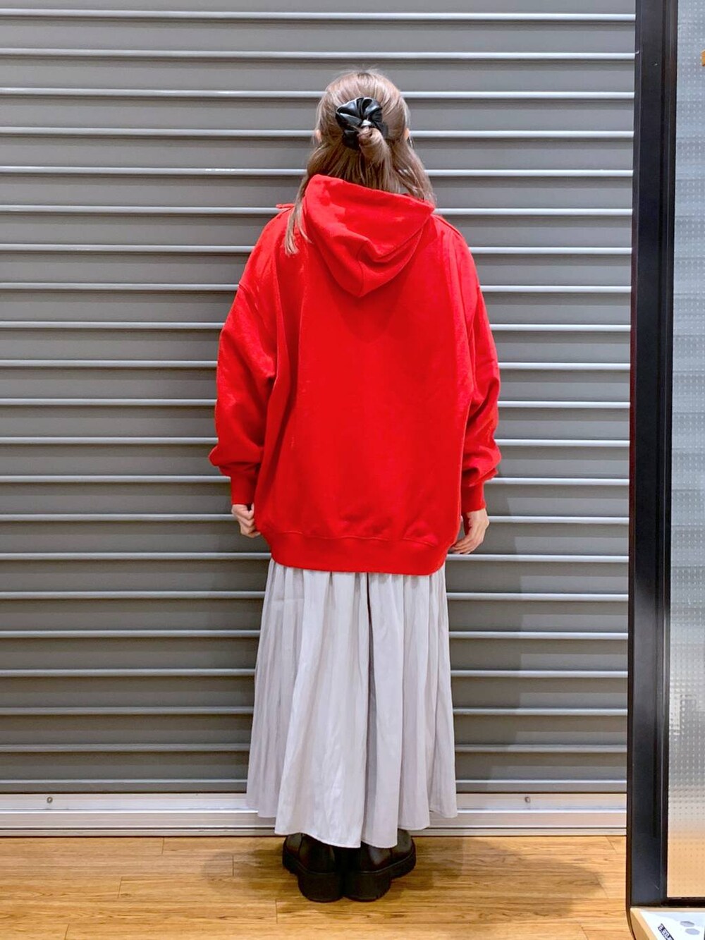 グレー系のその他パンツ、ブラック系のブーツ、レッド系のパーカーを着用したレディースの冬コーディネートの2枚目の写真