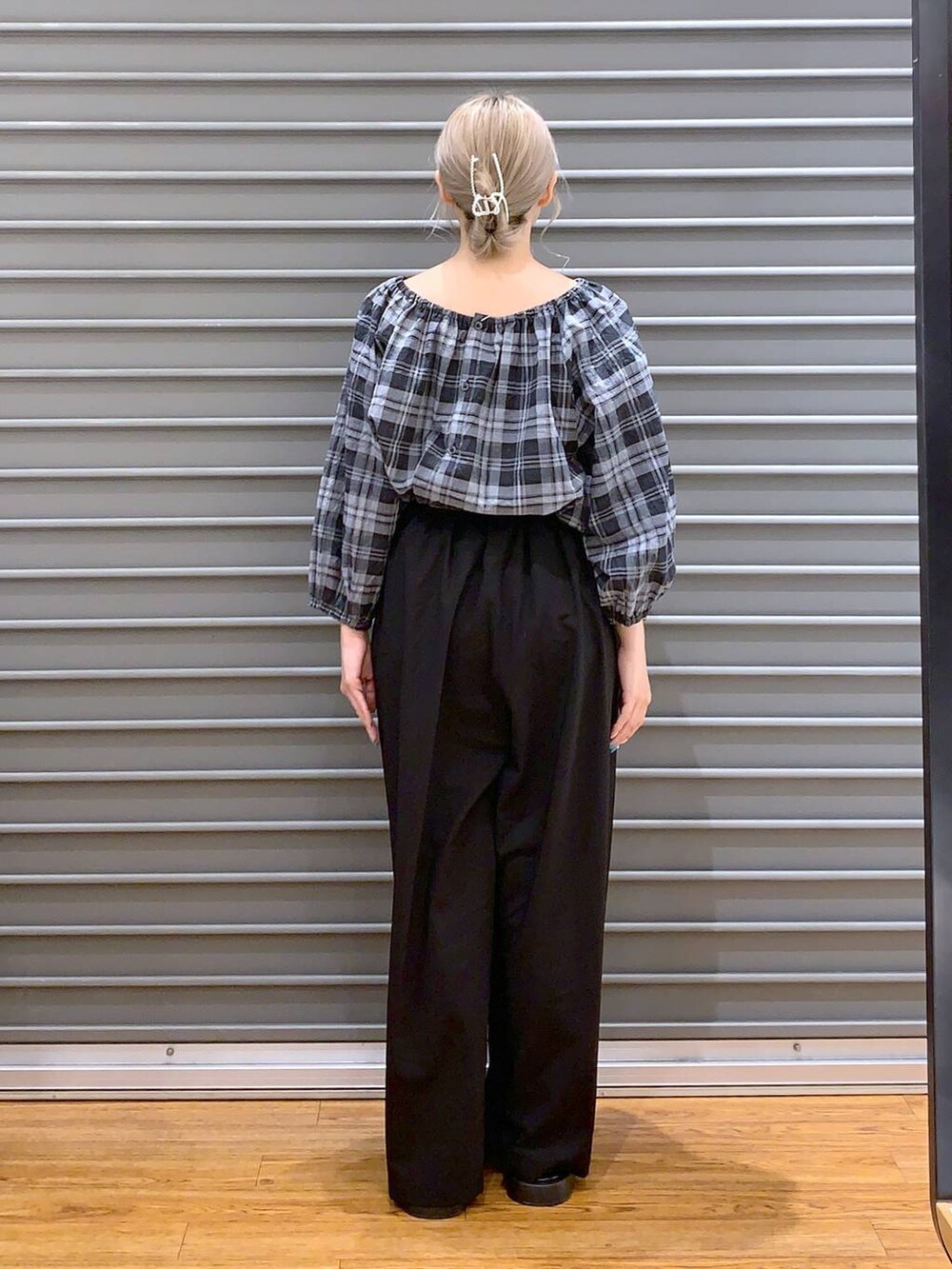 ブラック系のショルダーバッグ、シルバー系のサンダル、ブラック系のスラックスを着用したレディースの夏コーディネートの2枚目の写真