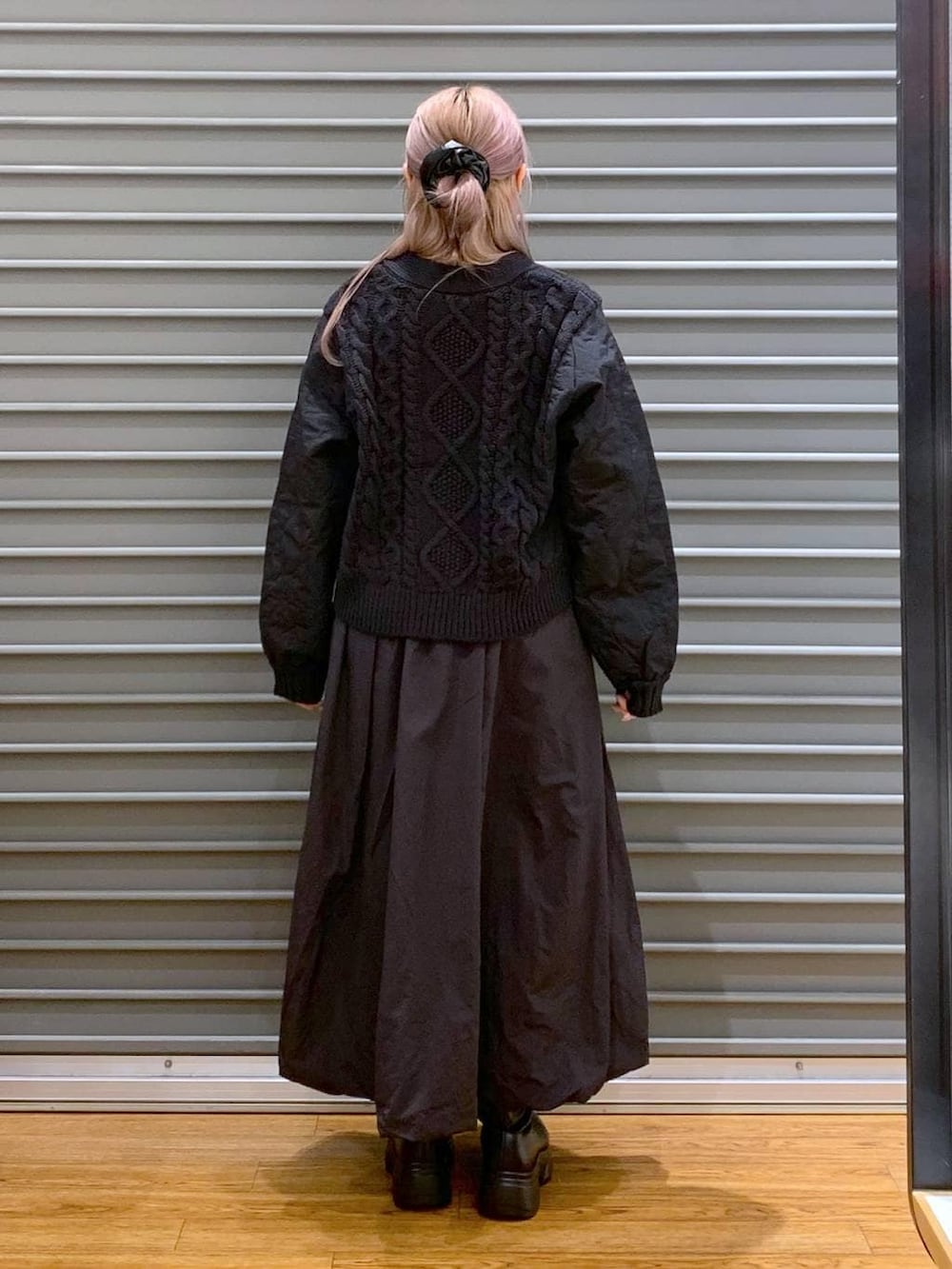 グレー系のショルダーバッグ、ブラック系のカーディガン/ボレロ、ブラック系のブーツを着用したレディースの冬コーディネートの2枚目の写真