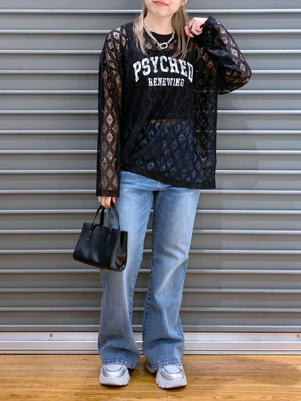 ブルー系のデニムパンツ、ブラック系のタンクトップ、シルバー系のスニーカーを着用したレディースの春コーディネートの3枚目の写真