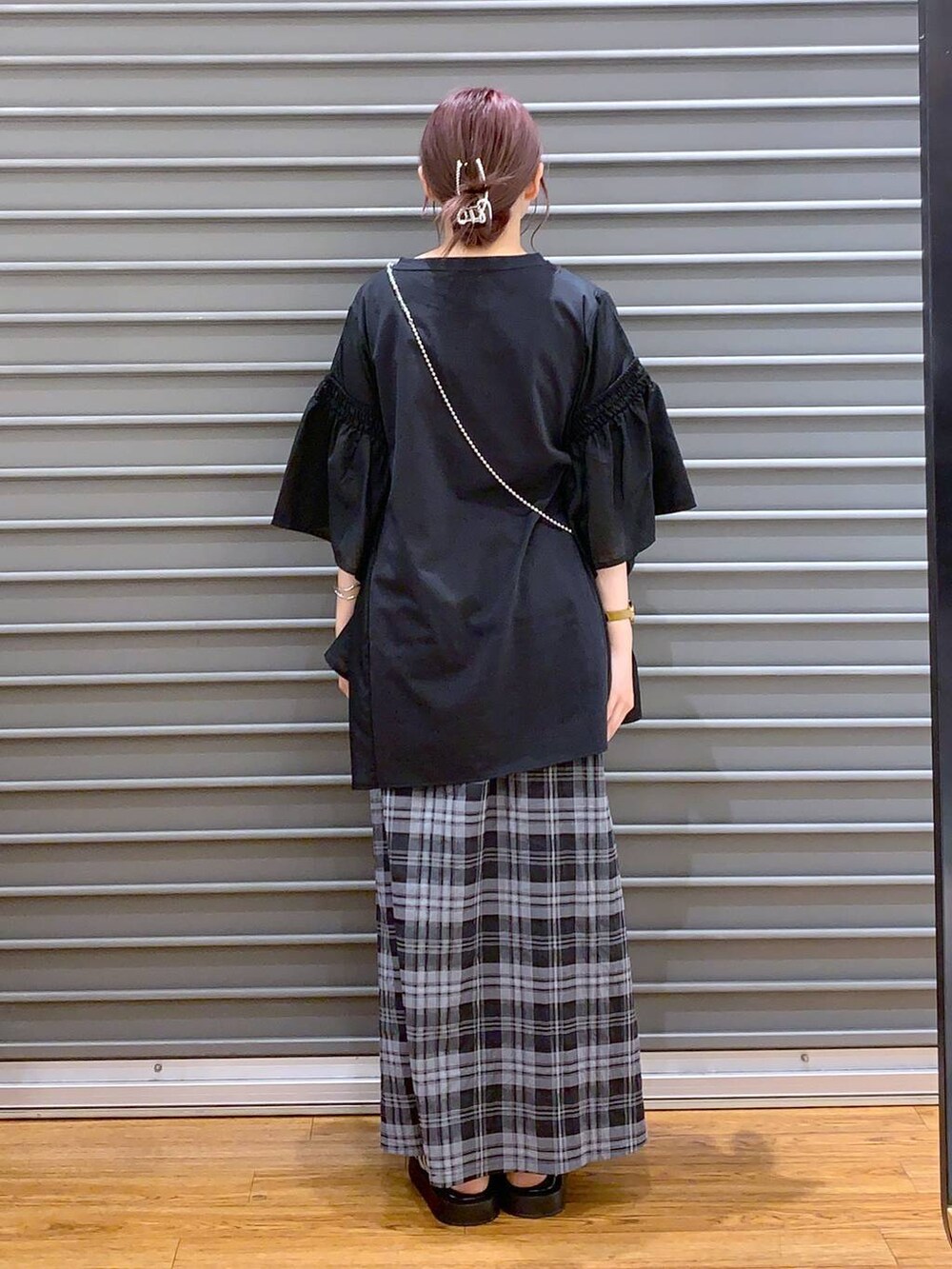 ブラック系のTシャツ/カットソー、シルバー系のサンダル、ホワイト系のスカートを着用したレディースの夏コーディネートの2枚目の写真