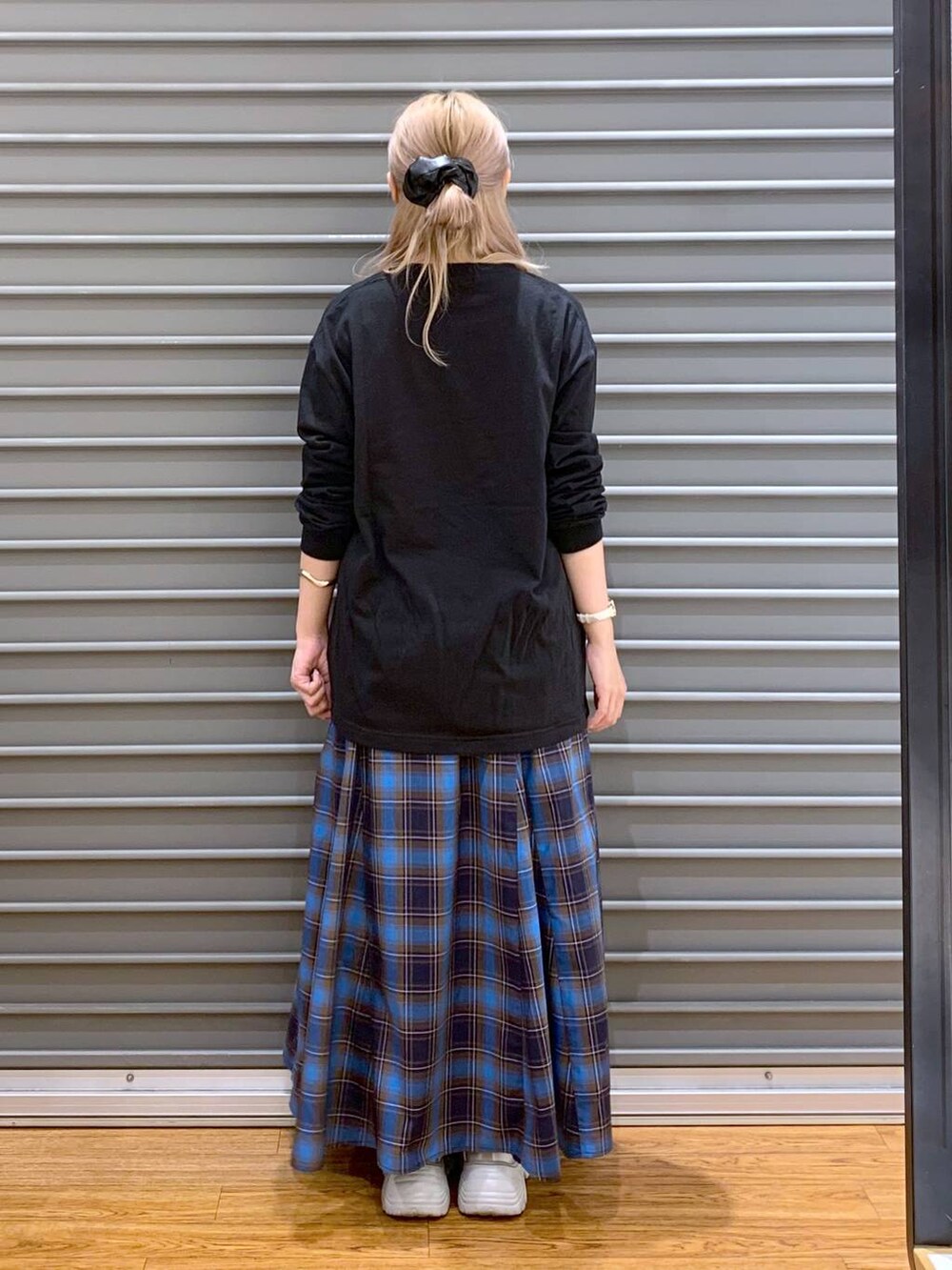 ブラック系のショルダーバッグ、ブラック系のスニーカー、ブルー系のカバーオールを着用したレディースの秋コーディネートの3枚目の写真