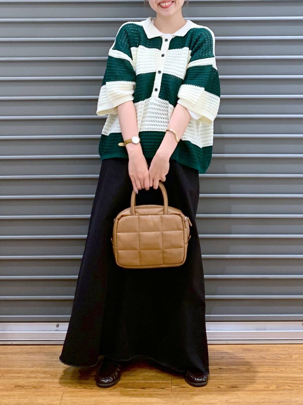 グリーン系のニット/セーター、グレー系のスカート、ブラウン系のボストンバッグを着用したレディースの秋コーディネートの7枚目の写真