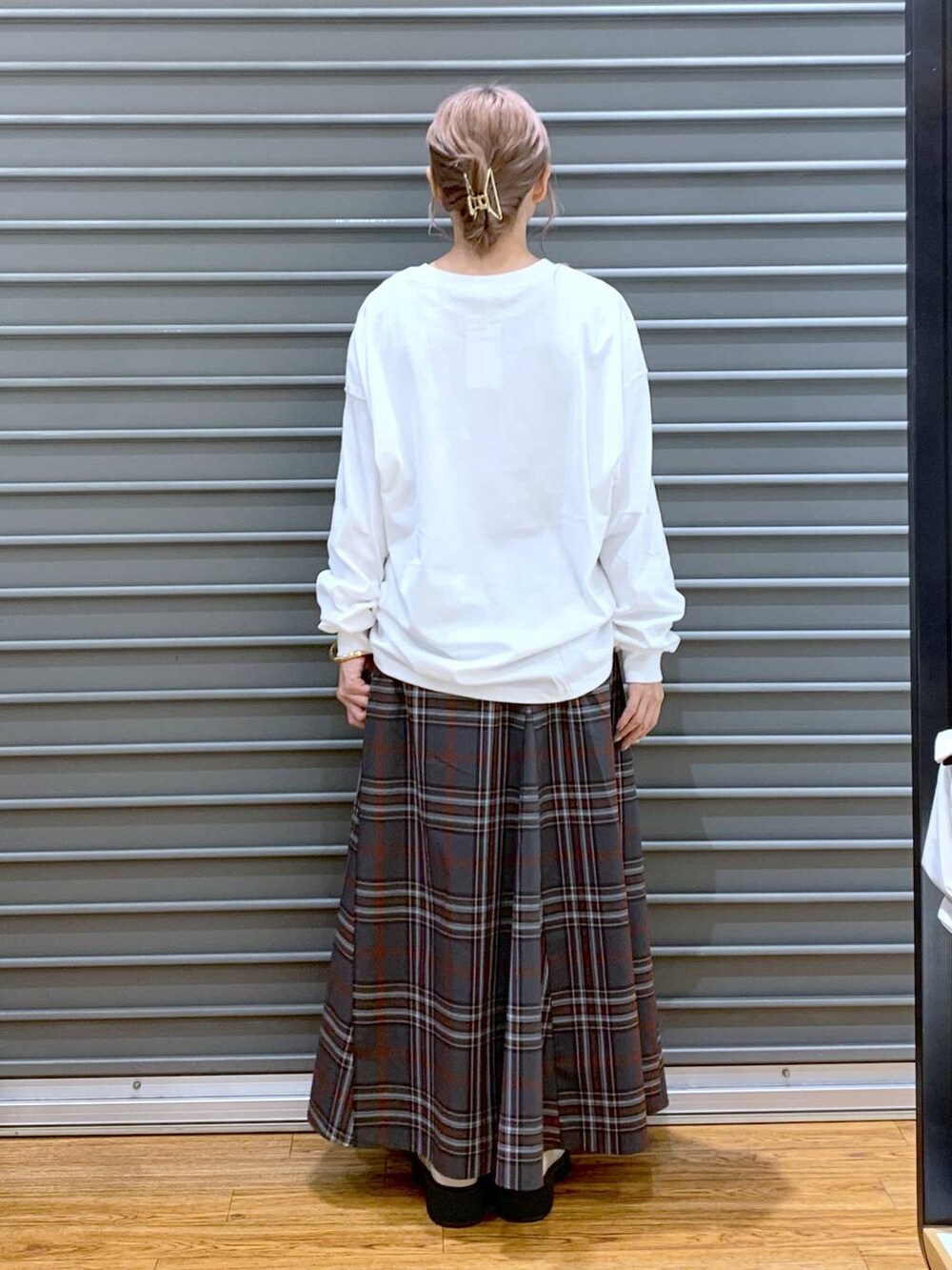 ホワイト系のブーツ、ブラウン系のボストンバッグ、グレー系のスカートを着用したレディースの秋コーディネートの2枚目の写真