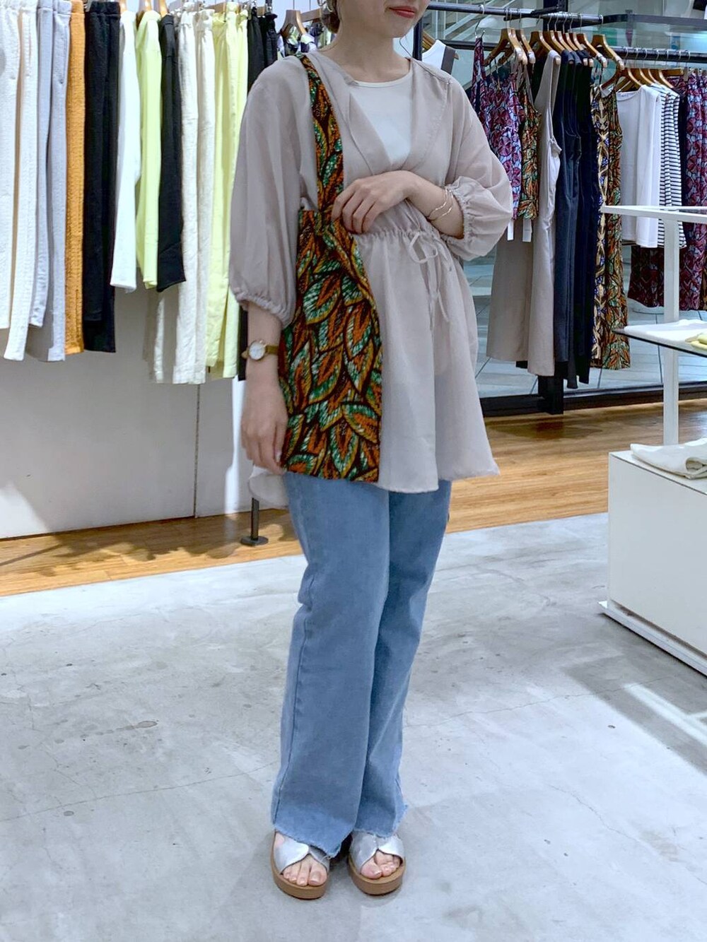 ベージュ系のシャツ/ブラウス、ブルー系のデニムパンツ、シルバー系のサンダルを着用したレディースの夏コーディネートの5枚目の写真