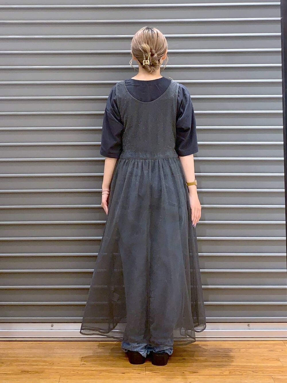 ブラック系のショルダーバッグ、ブルー系のデニムパンツ、ホワイト系のサンダルを着用したレディースの秋コーディネートの2枚目の写真