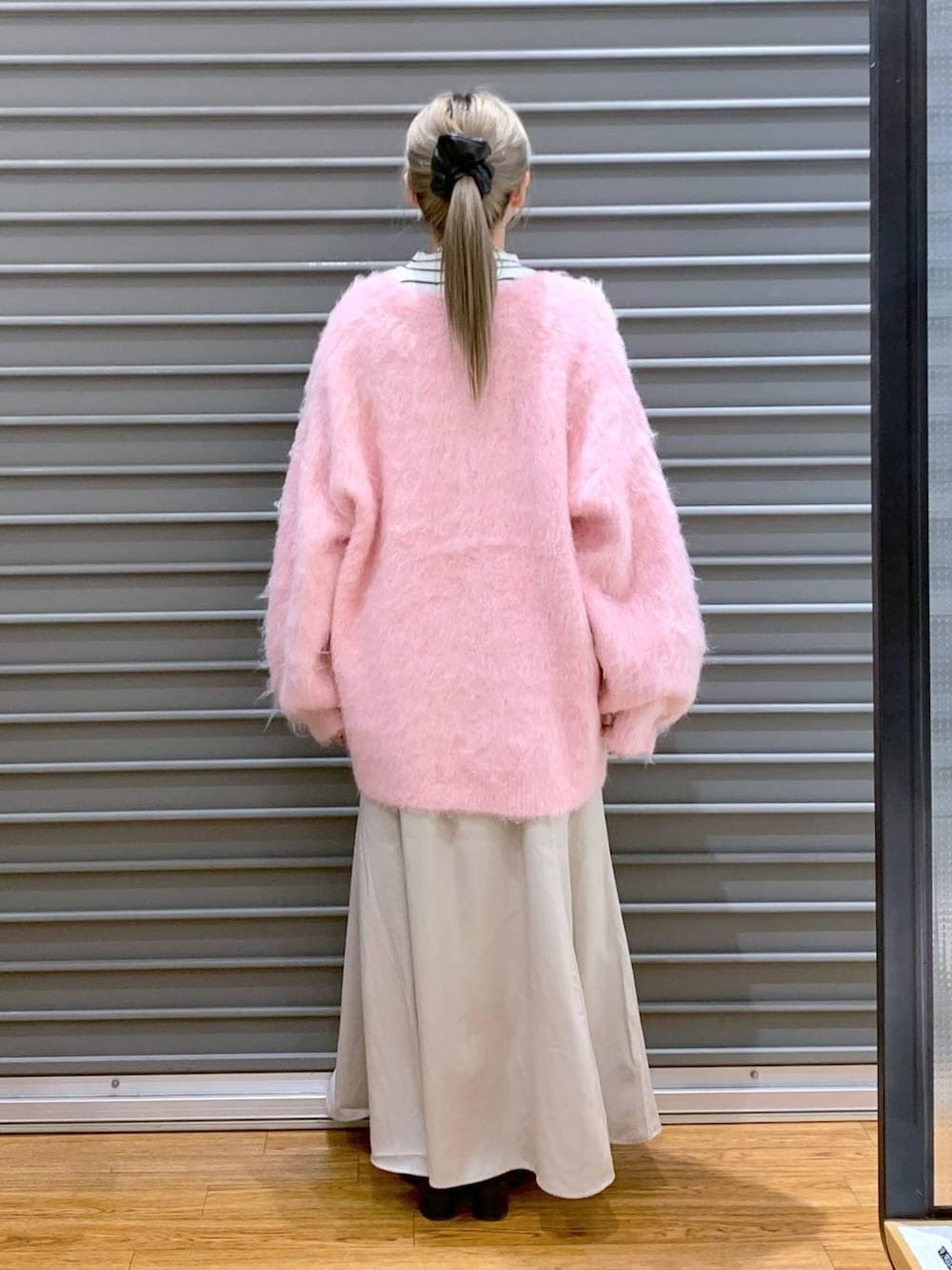 ブラック系のショルダーバッグ、ホワイト系のニット/セーター、ブラック系のブーツを着用したレディースの冬コーディネートの3枚目の写真