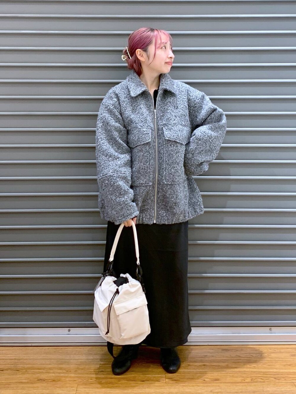 ホワイト系のショルダーバッグ、ブラック系のスカート、ブラック系のブーツを着用したレディースの秋コーディネートの4枚目の写真