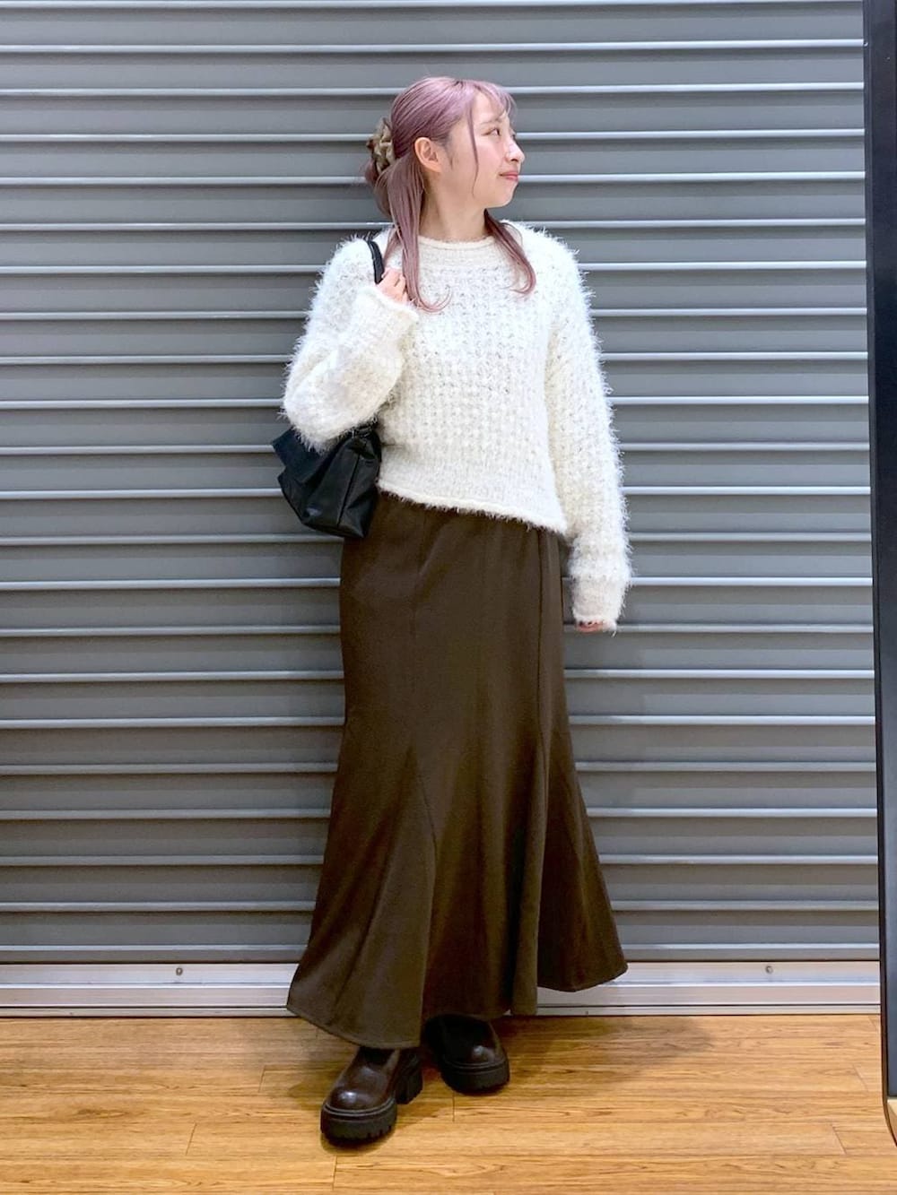 ブラウン系のブーツ、ホワイト系のニット/セーター、ブラック系のショルダーバッグを着用したレディースの冬コーディネートの4枚目の写真