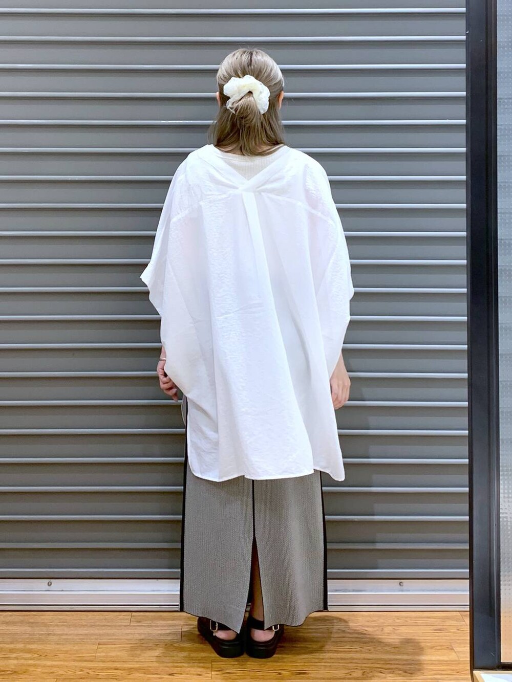 ホワイト系のTシャツ/カットソー、ブラック系のスカート、ブラック系のサンダルを着用したレディースの夏コーディネートの2枚目の写真