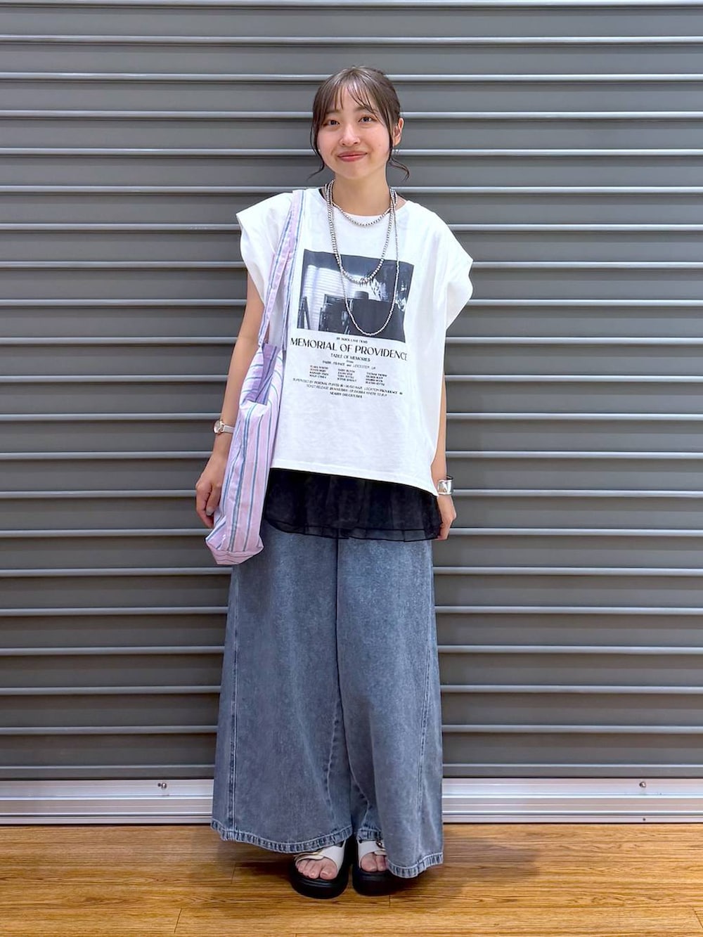 パープル系のトートバッグ、ホワイト系のサンダル、ホワイト系のTシャツ/カットソーを着用したレディースの夏コーディネートの5枚目の写真