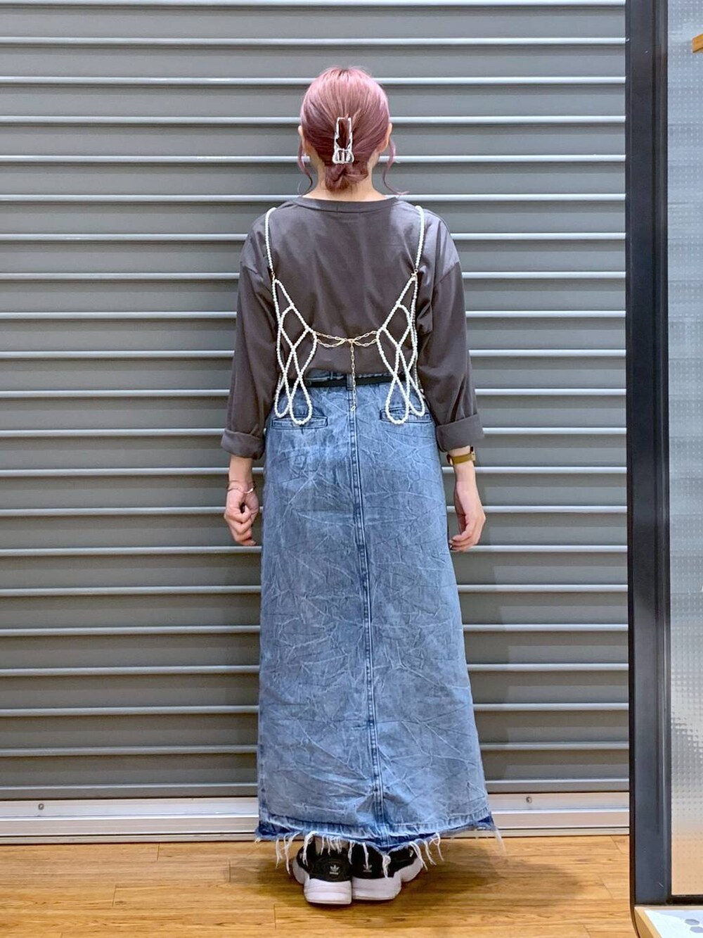 ホワイト系のベスト、ブルー系のデニムスカート、グレー系のTシャツ/カットソーを着用したレディースの秋コーディネートの2枚目の写真